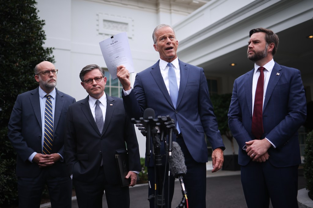 U.S. Senate Majority Leader John Thune holds up a copy of a clean CR, flanked by Russell Vought, Mike Johnson, and JD Vance.