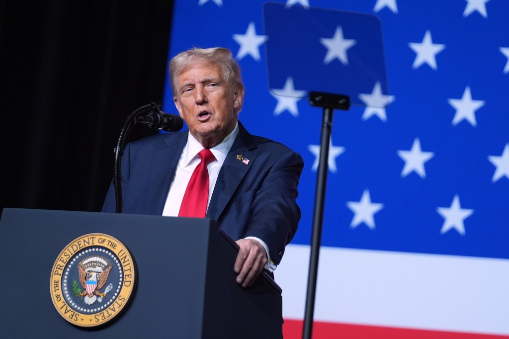 Donald Trump speaking at a podium with the Seal of the President of the United States, in front of a blue background with white stars.