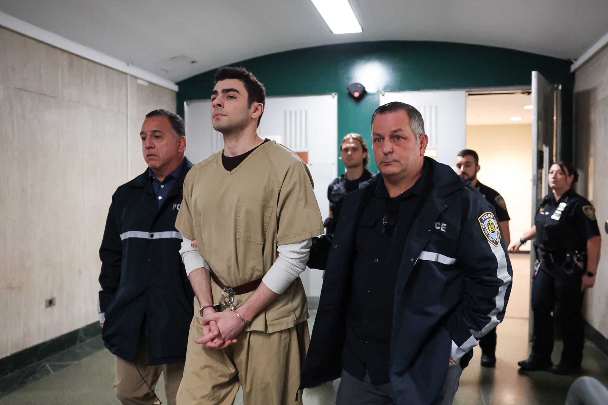 Luigi Mangione is escorted into state court in Manhattan, where a judge dismissed the top murder-as-terrorism counts.