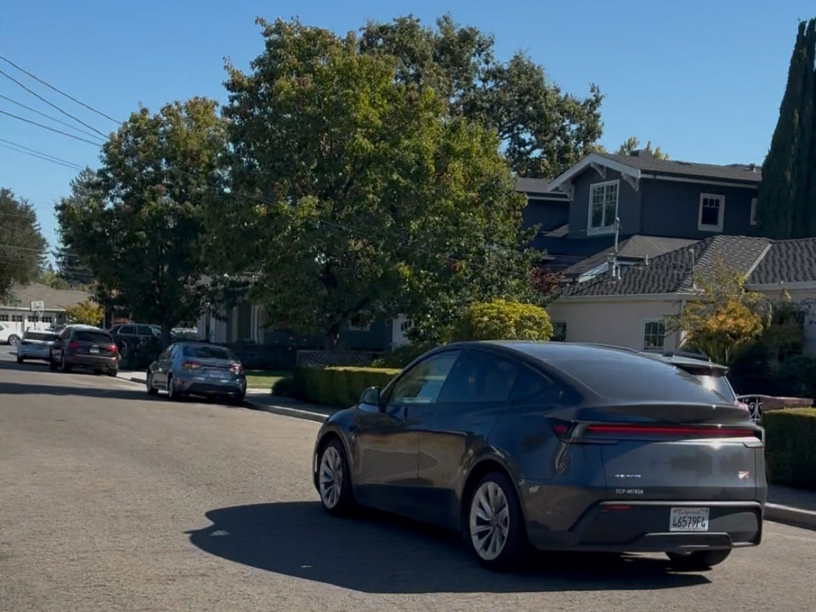 A Tesla Robotaxi stopping to pick up a rider in Silicon Valley