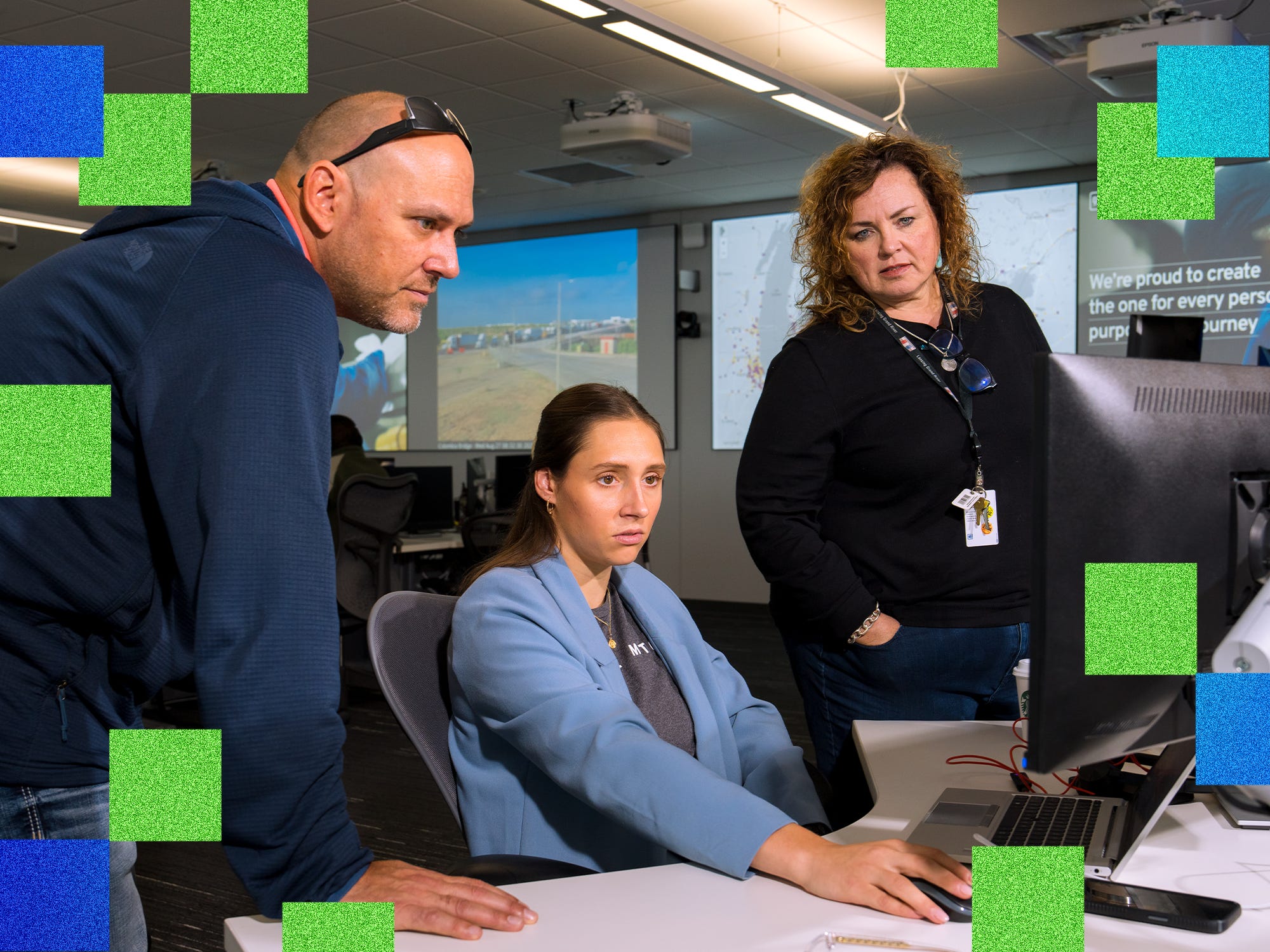 Three people watch the weather on a monitor at GM's Technical Center in Warren, Michigan.