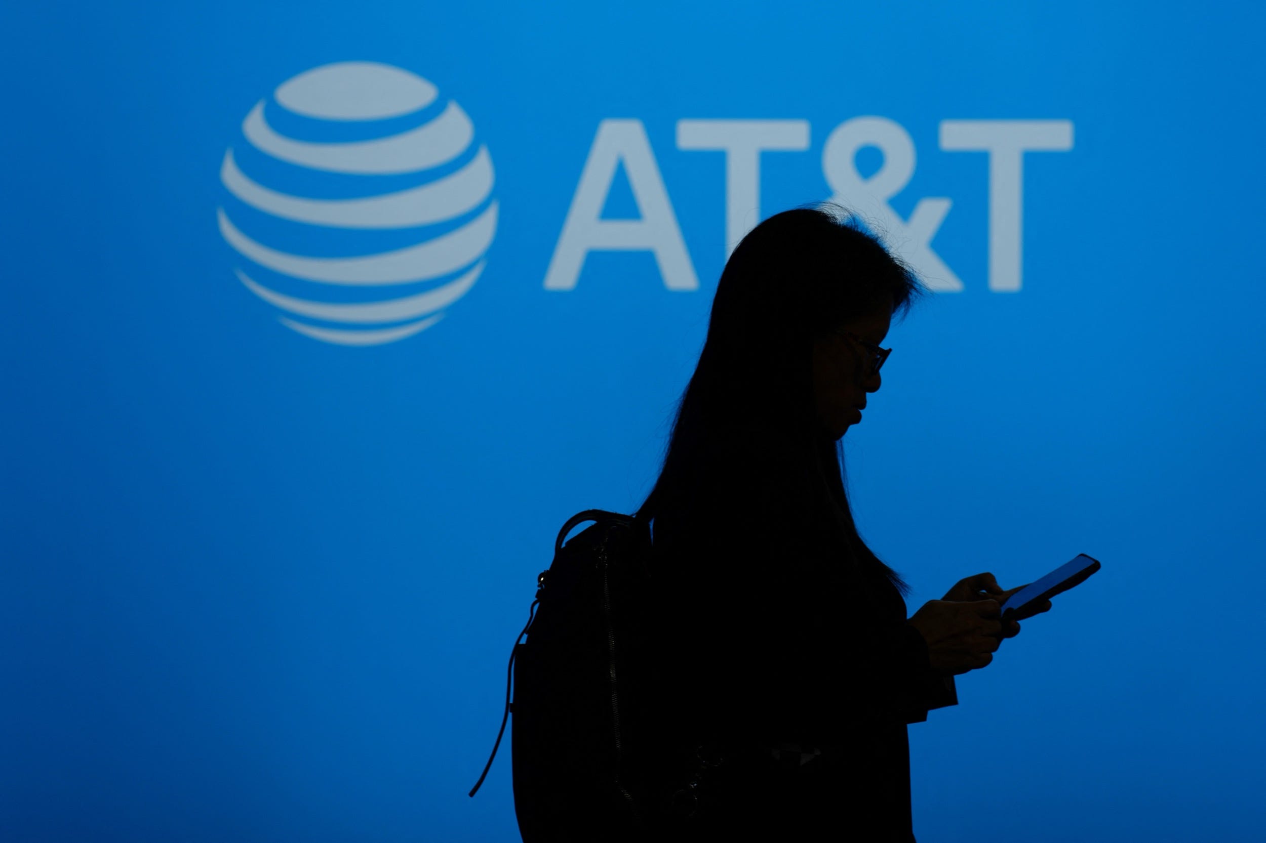 A visitor walks past US multinational telecommunications AT&T logo during the 2024 Mobile World Congress (MWC), the telecom industry's biggest annual gathering, in Barcelona.