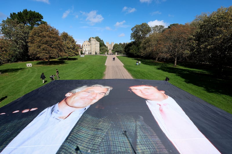 A large banner depicting U.S. President Donald Trump alongside disgraced financier Jeffrey Epstein is displayed near the Windsor Castle by campaign group 'Everyone Hates Elon', protesting Trump's state visit to the country, in Windsor, Britain, September 15, 2025. REUTERS/Hannah McKay REFILE - CORRECTING NAME OF CAMPAIGN GROUP FROM 