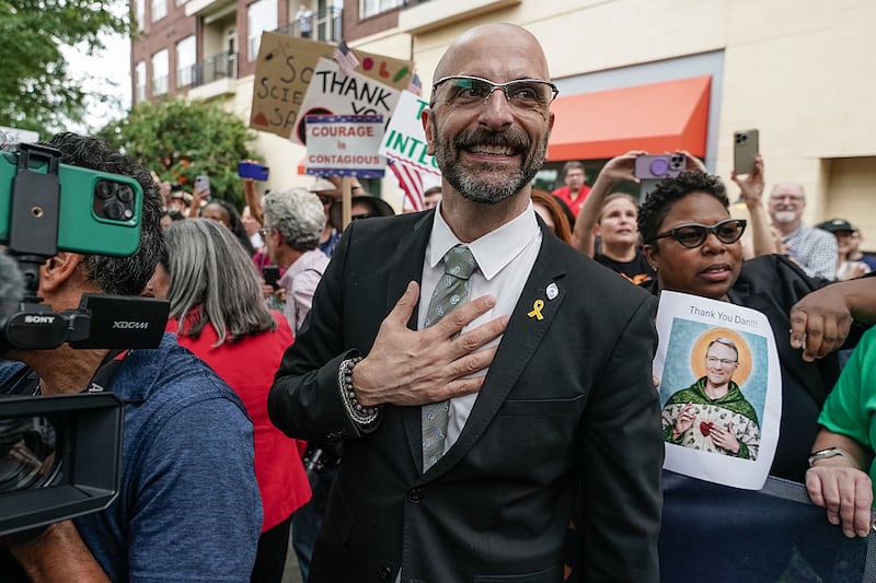 Former Centers for Disease Control (CDC) official Demetre Daskalakis places his hand over his heart as employees and supporters of the CDC cheer and clap to honor him, Dan Jernigan, and Deb Houry outside its global headquarters on August 28, 2025 in Atlanta, Georgia. The three officials were honored after resigning in the wake of U.S. President Donald Trump's attempted firing of CDC director Susan Monarez. (Photo by Elijah Nouvelage/Getty Images)
