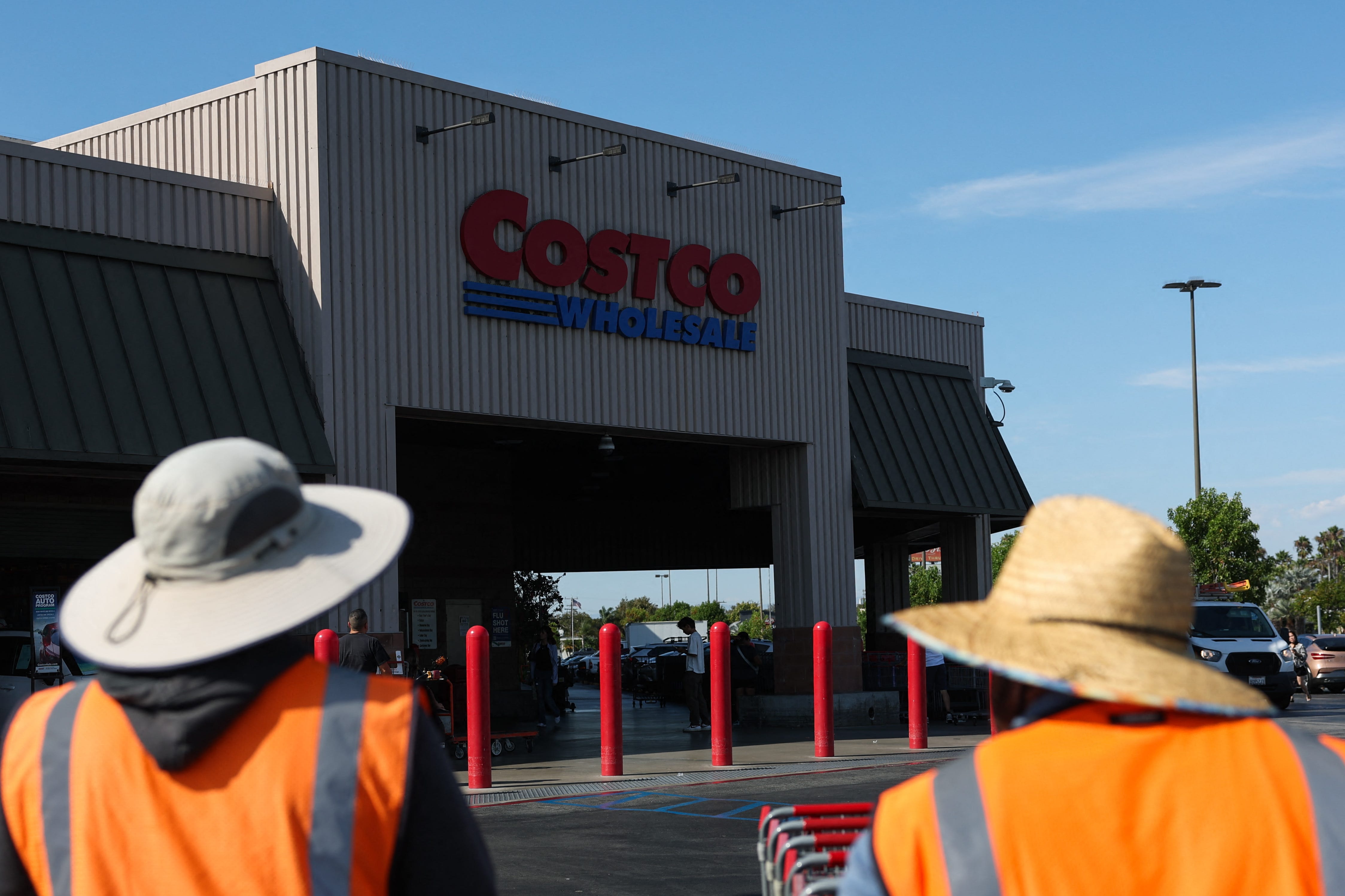 Employees push shopping carts outside a Costco Wholesale warehouse store in Hawthorne, California.