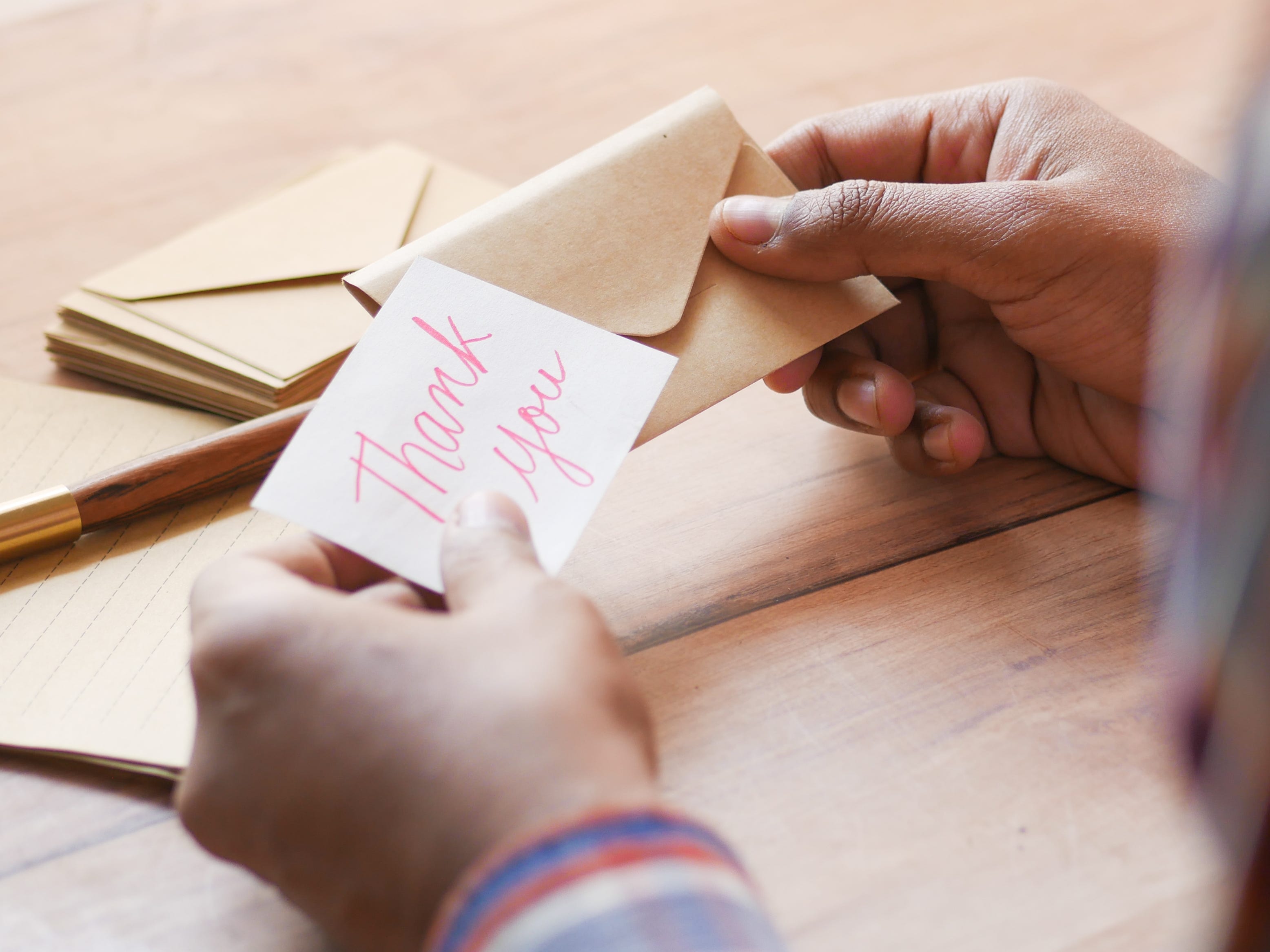 Close-up of hands holding a thank-you card and envelope.