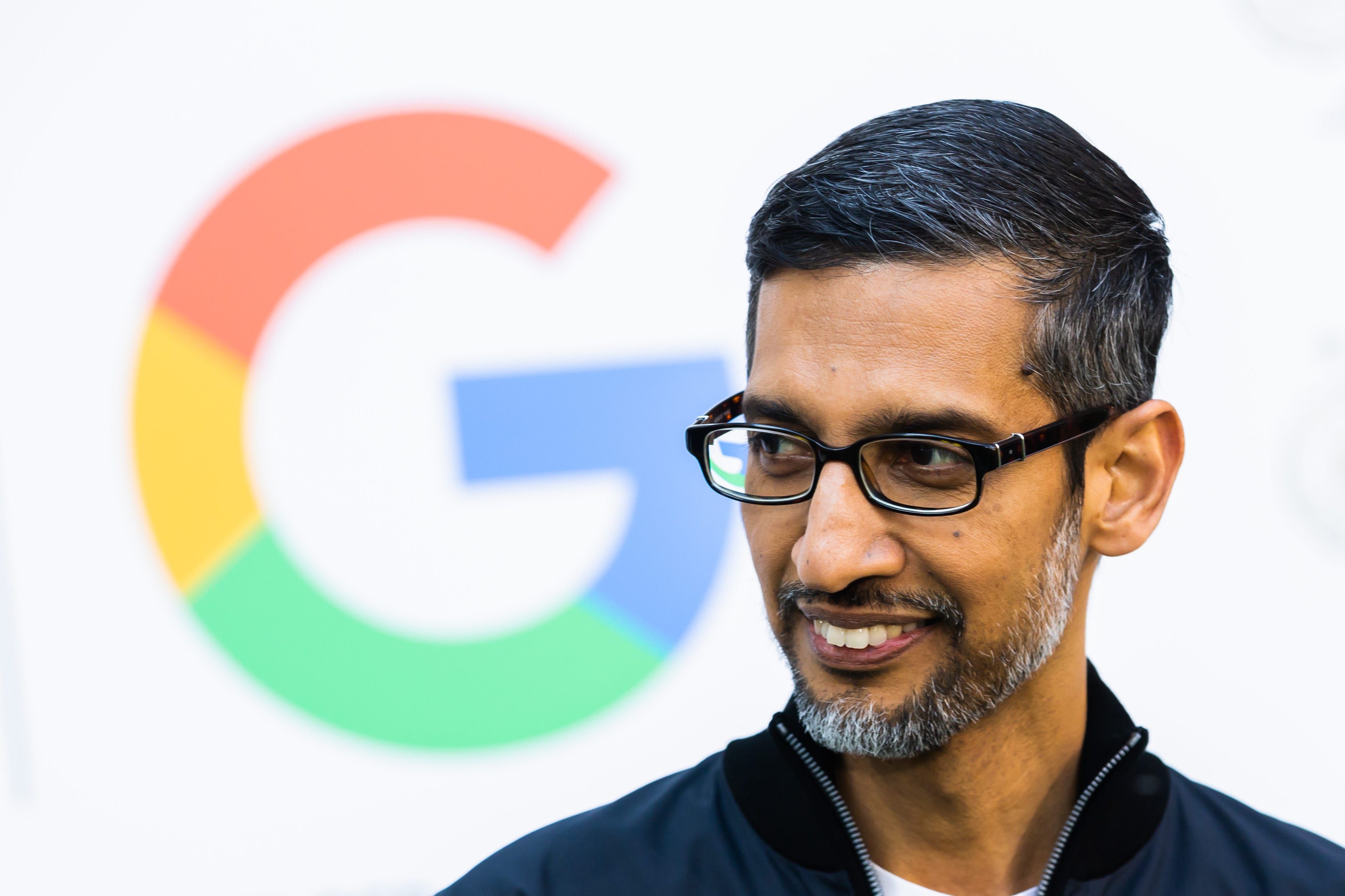 Google CEO Sundar Pichai in front of the Google logo.
