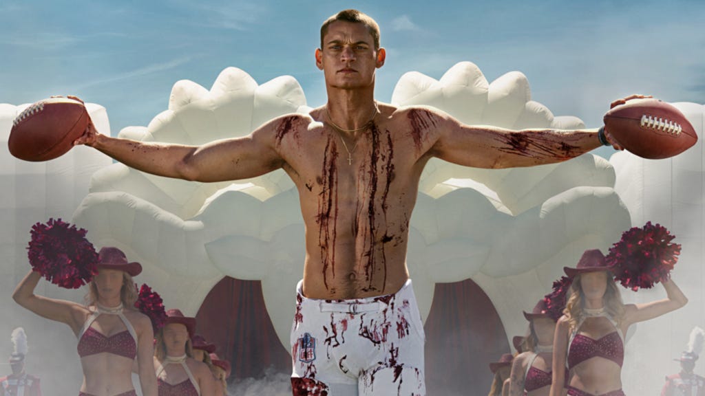 Tyriq Withers holding football in his hands with blood on his chest and arms
