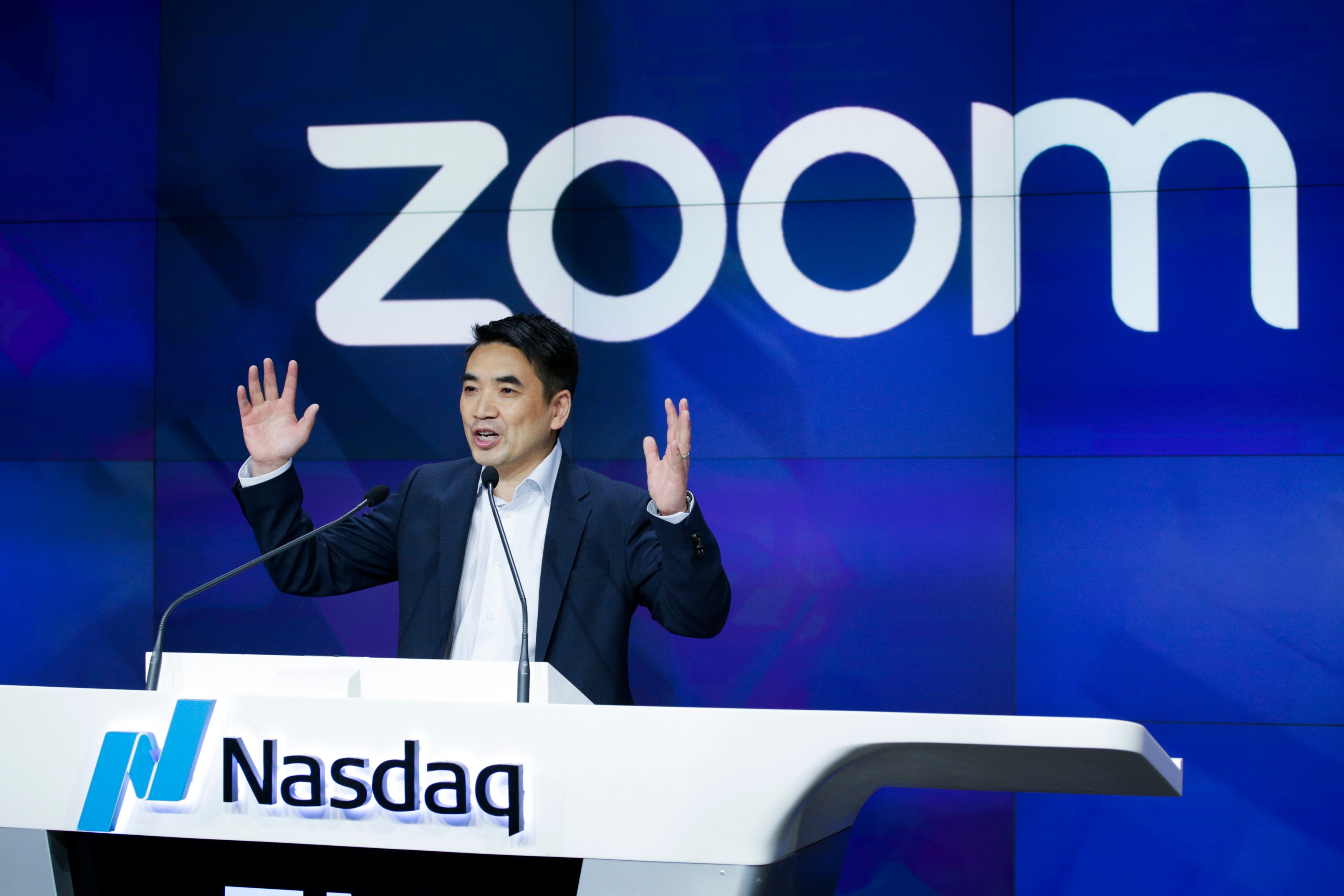 Eric Yuan is raising his arms as he talks at the Nasdaq opening bell ceremony in New York.