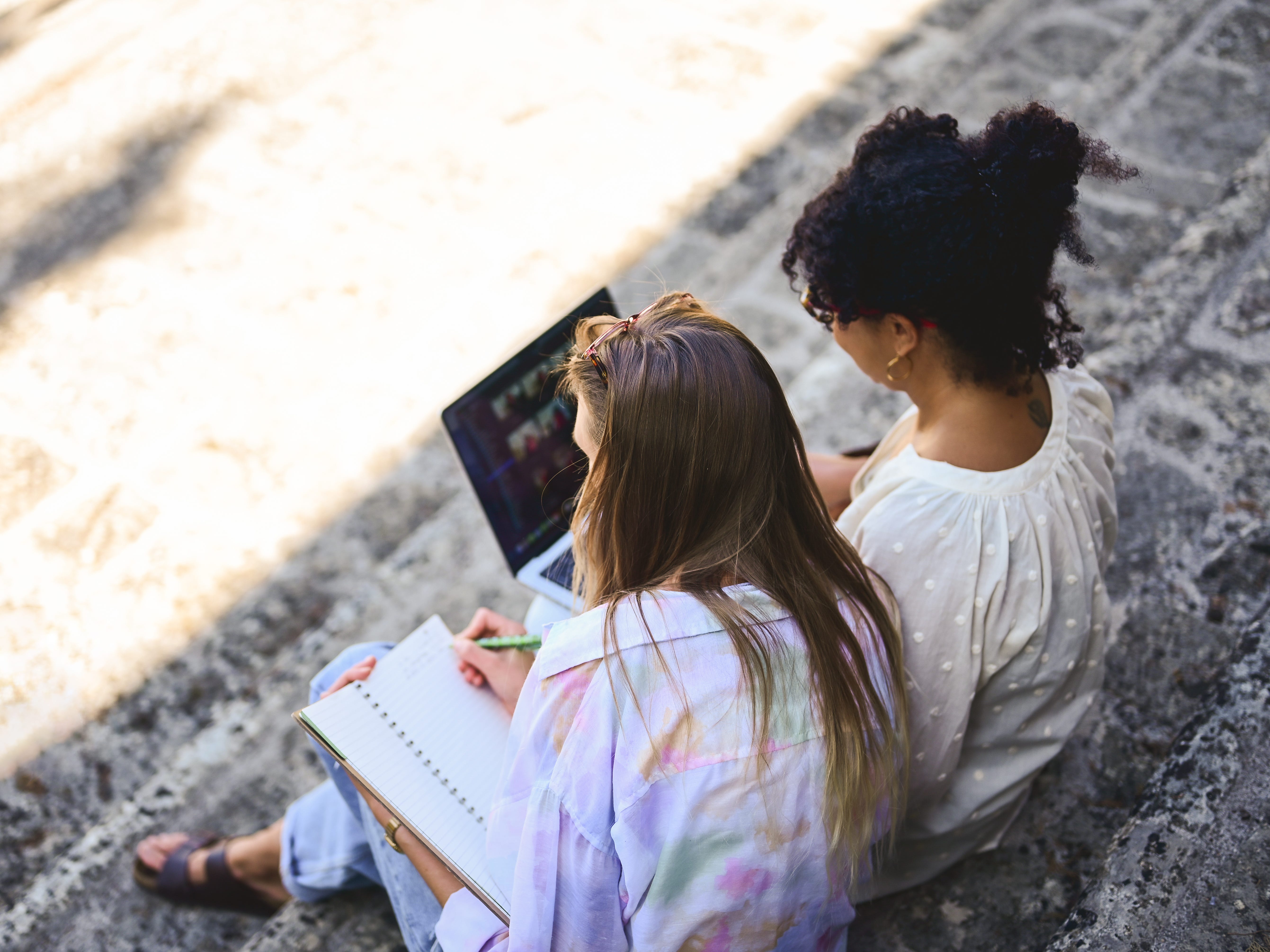 two female students looking at their notebook and laptop