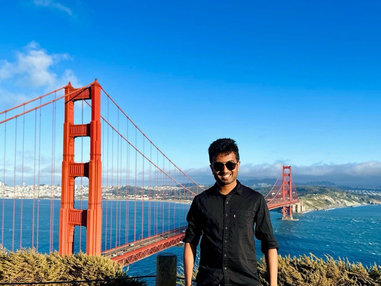 Man stands in front of Golden Gate Bridge.