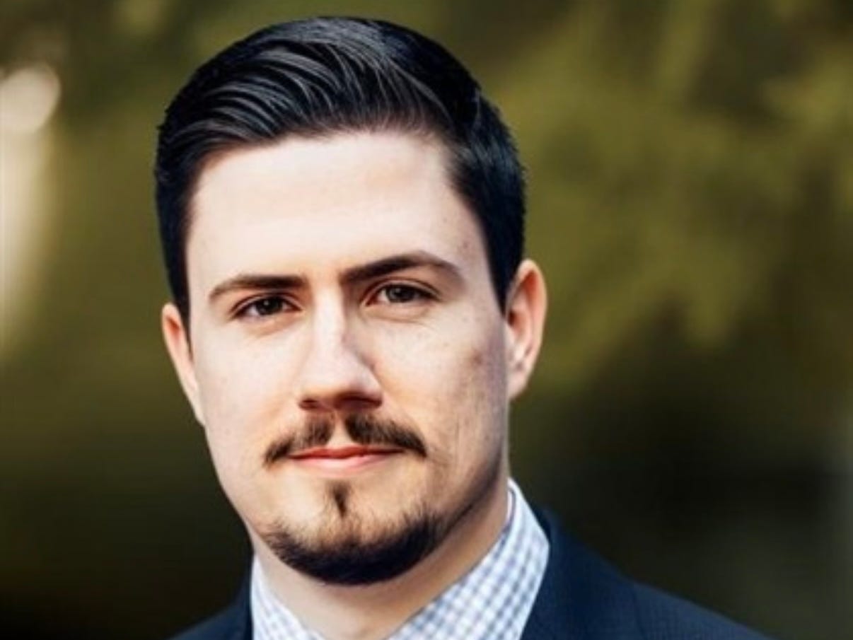 headshot of a man with a green background