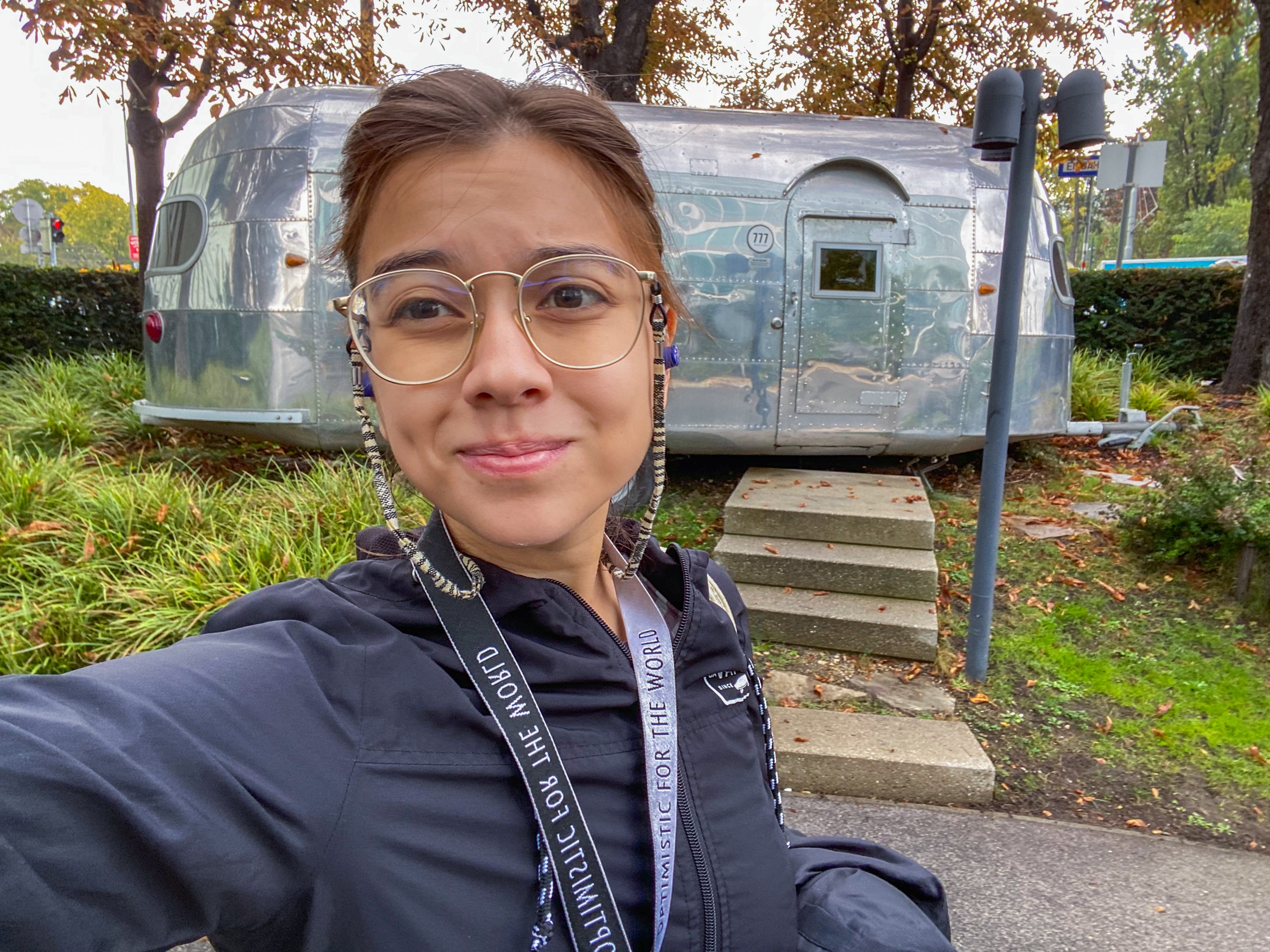 The author takes a selfie in front of an airstream trailer in a parking lot