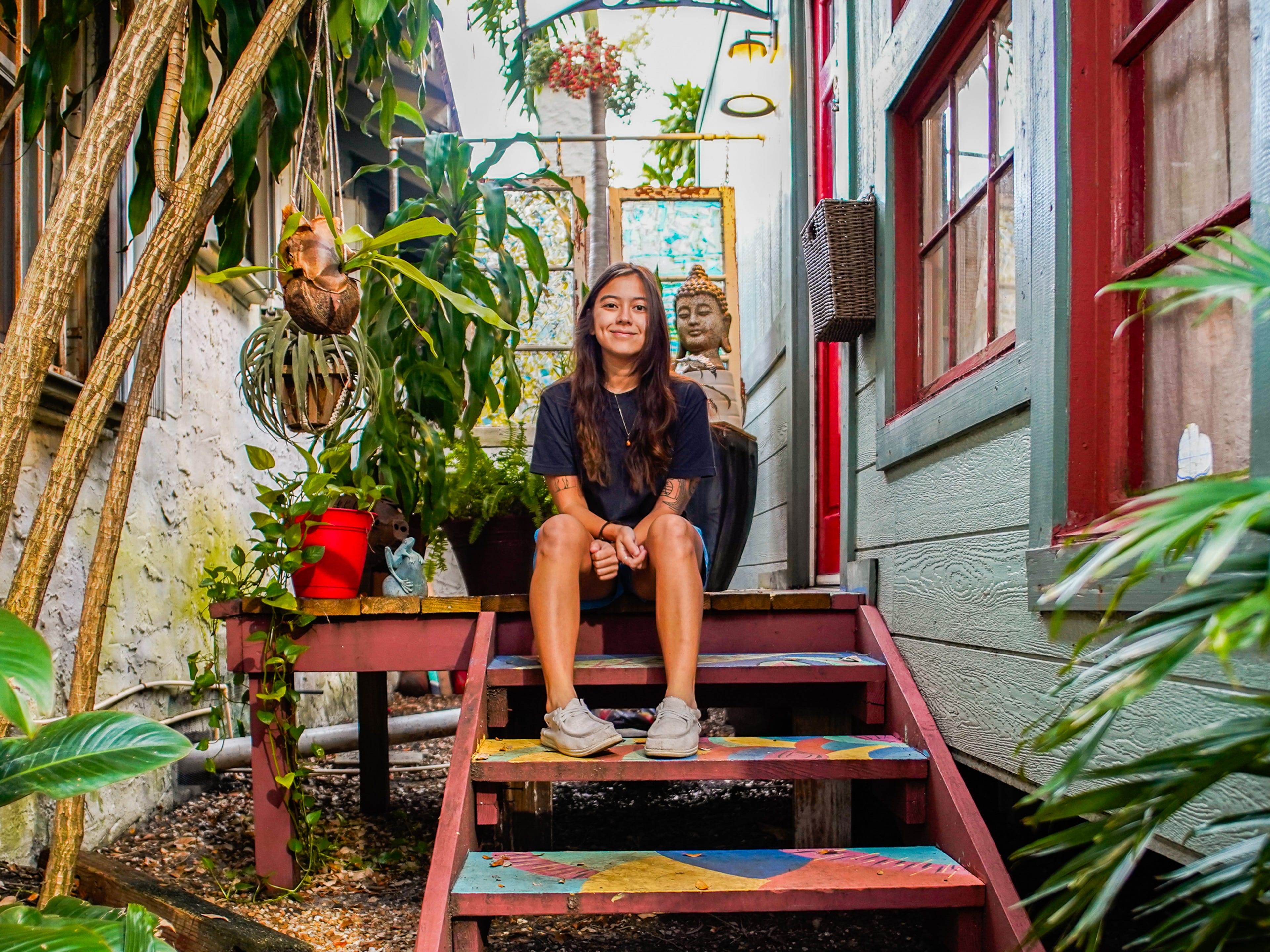 The author sits on the steps in front of the tiny home
