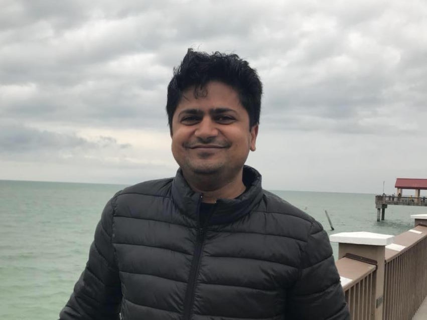a man posing near the ocean