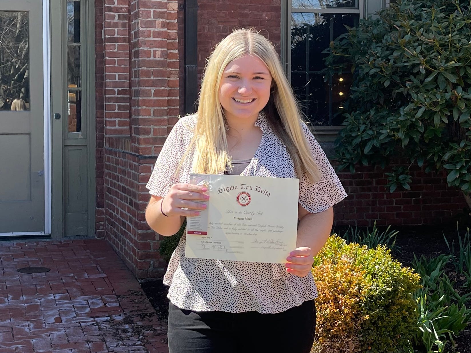 Morgan Rizzo holding up her college degree