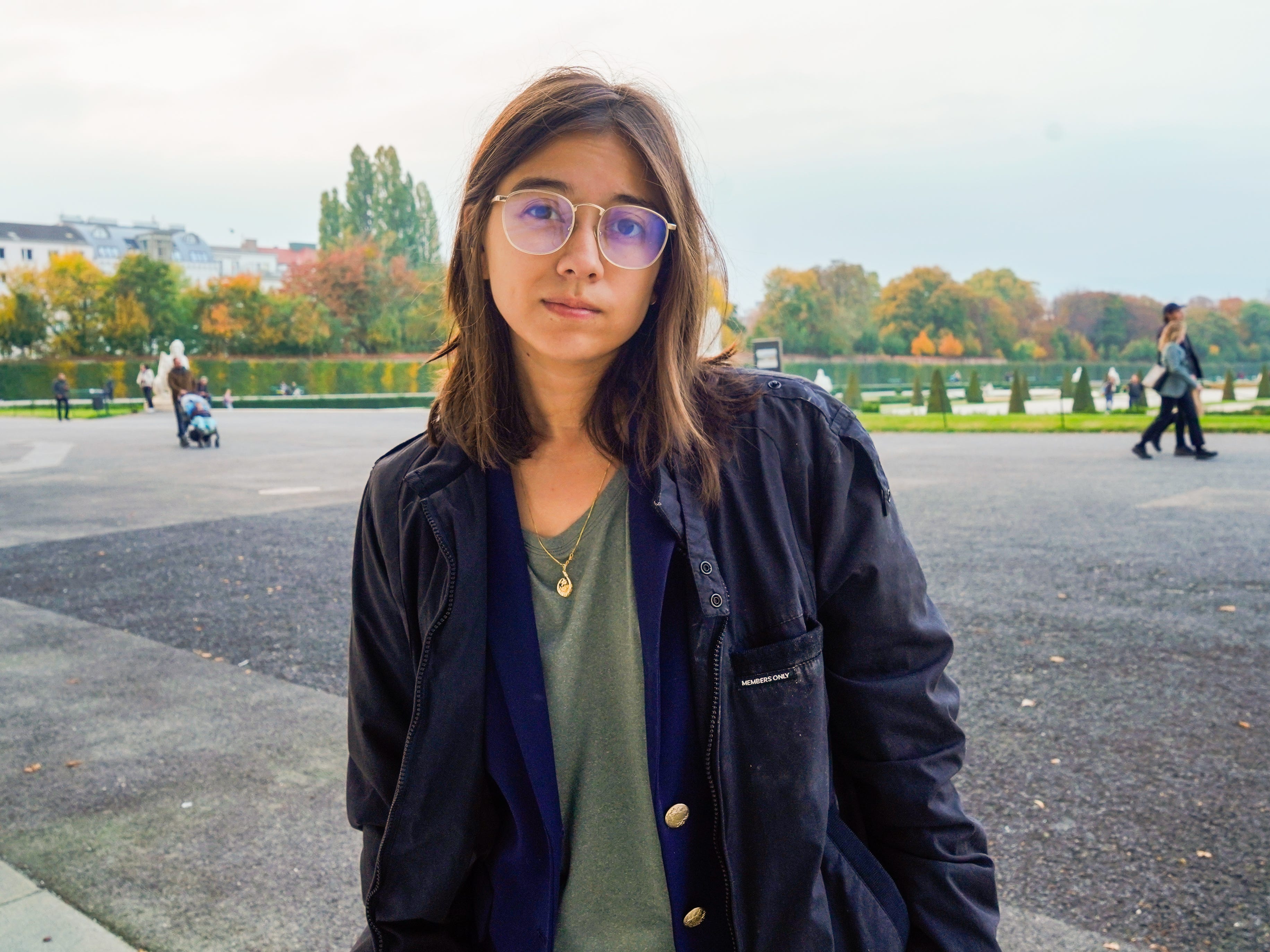 The author stands in front of a garden in Vienna