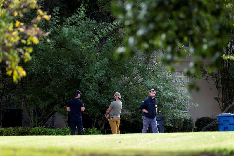 Law enforcement personnel gather outside the Fairview home of Joshua Jahn