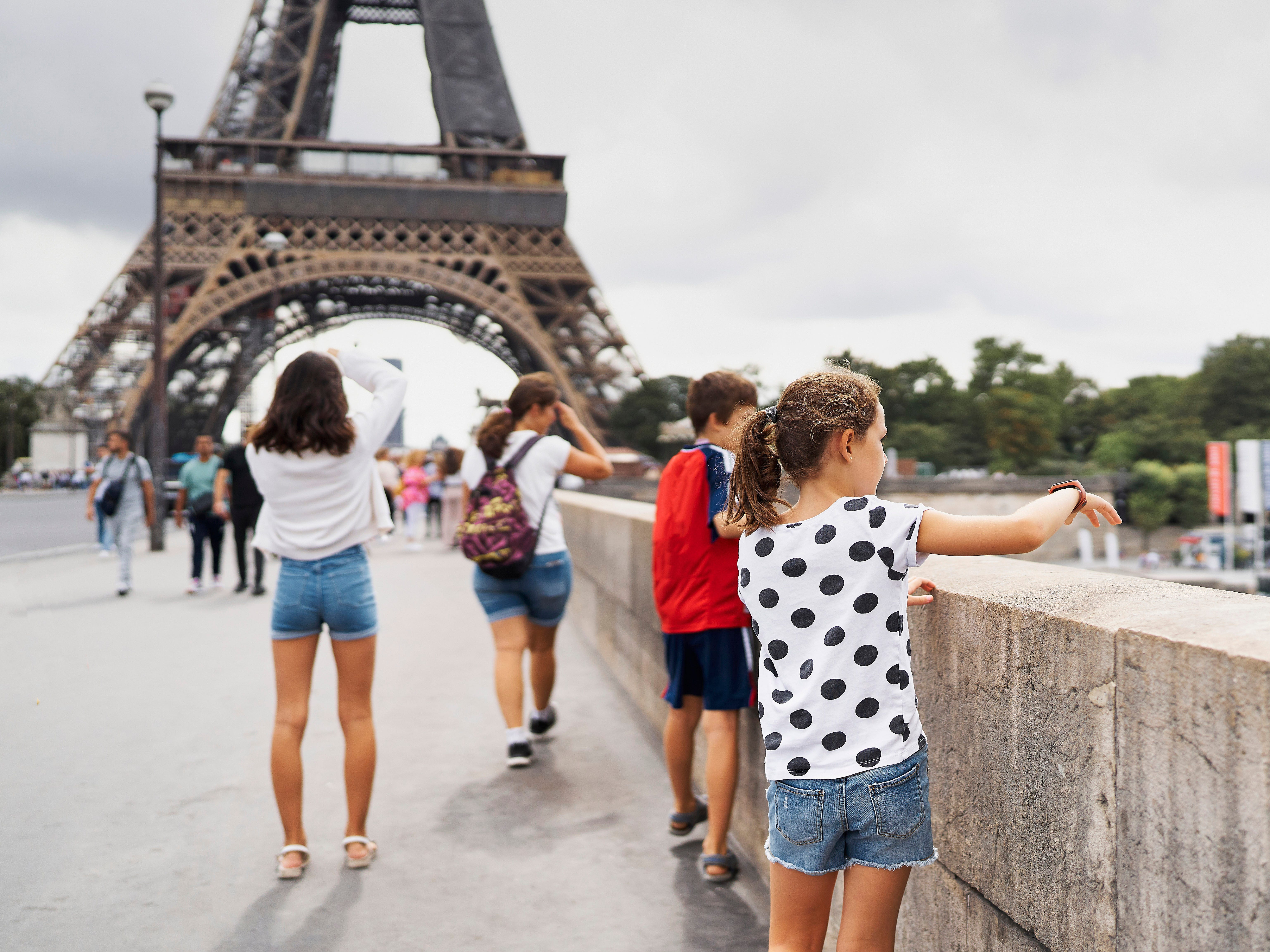 rear view of a group of boys standing on the street leaning on a handrail in Paris with the Eiffel tower in the background