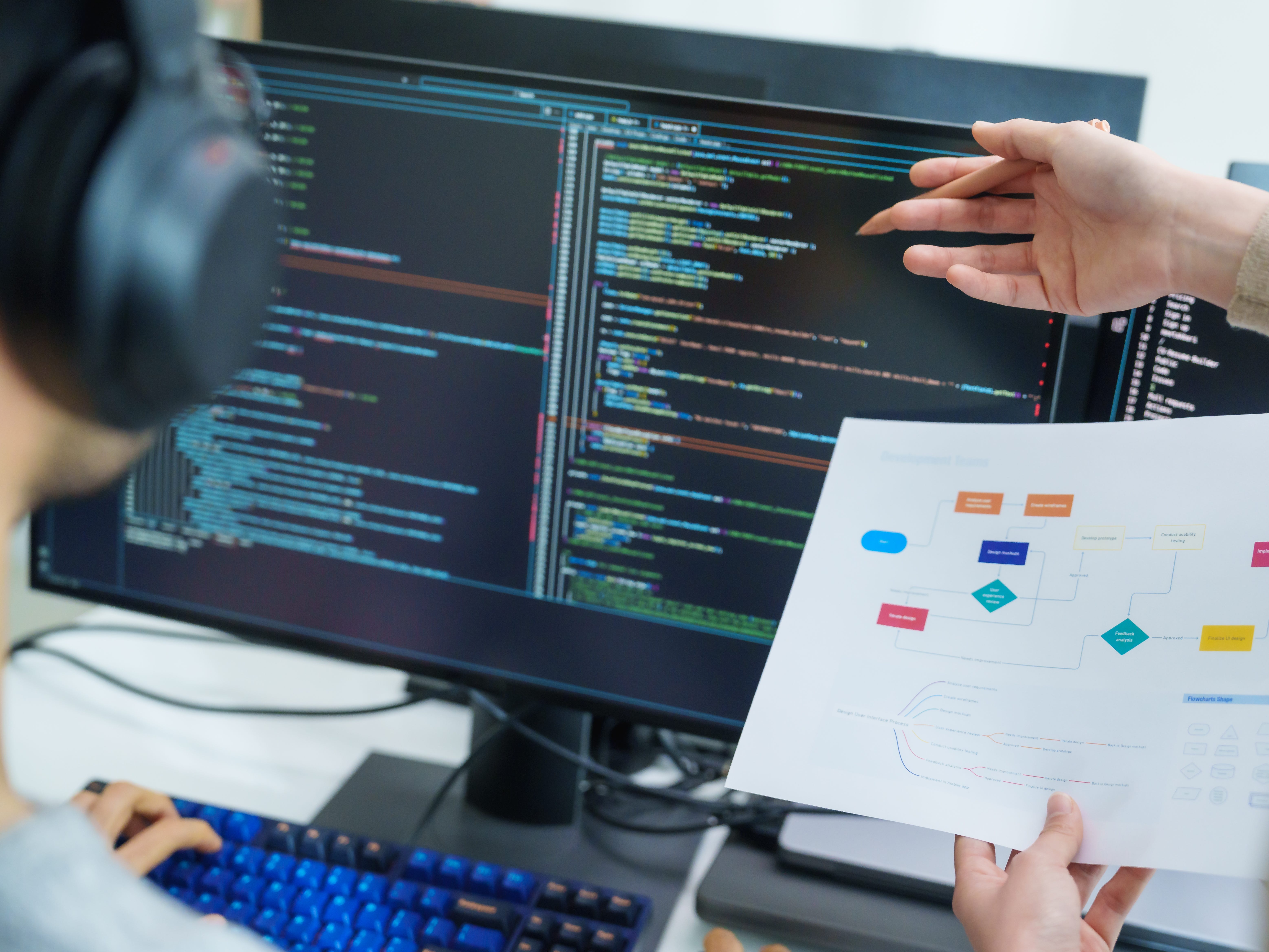 someone working at desk with code on screen
