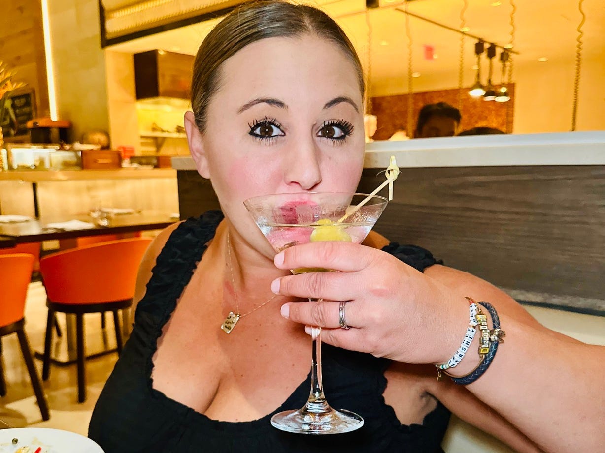 Author Carly Caramanna sipping cocktail at Four Seasons