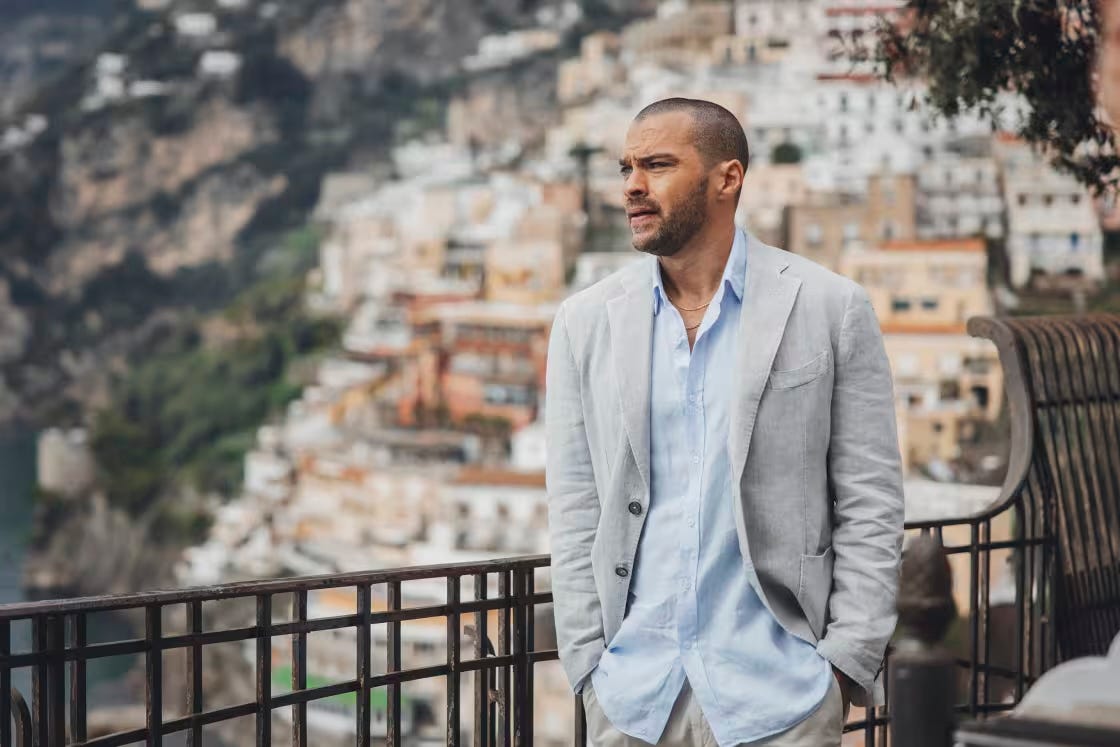 Actor Jesse Williams portrays Daniel De Luca. He's standing in Italy with his hands in his pockets, looking distressed.