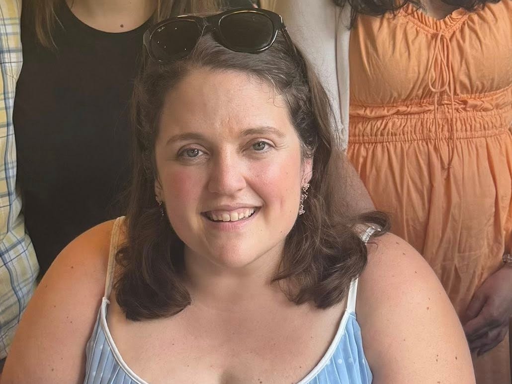 The author wearing a blue tank top and sunglasses on her head.