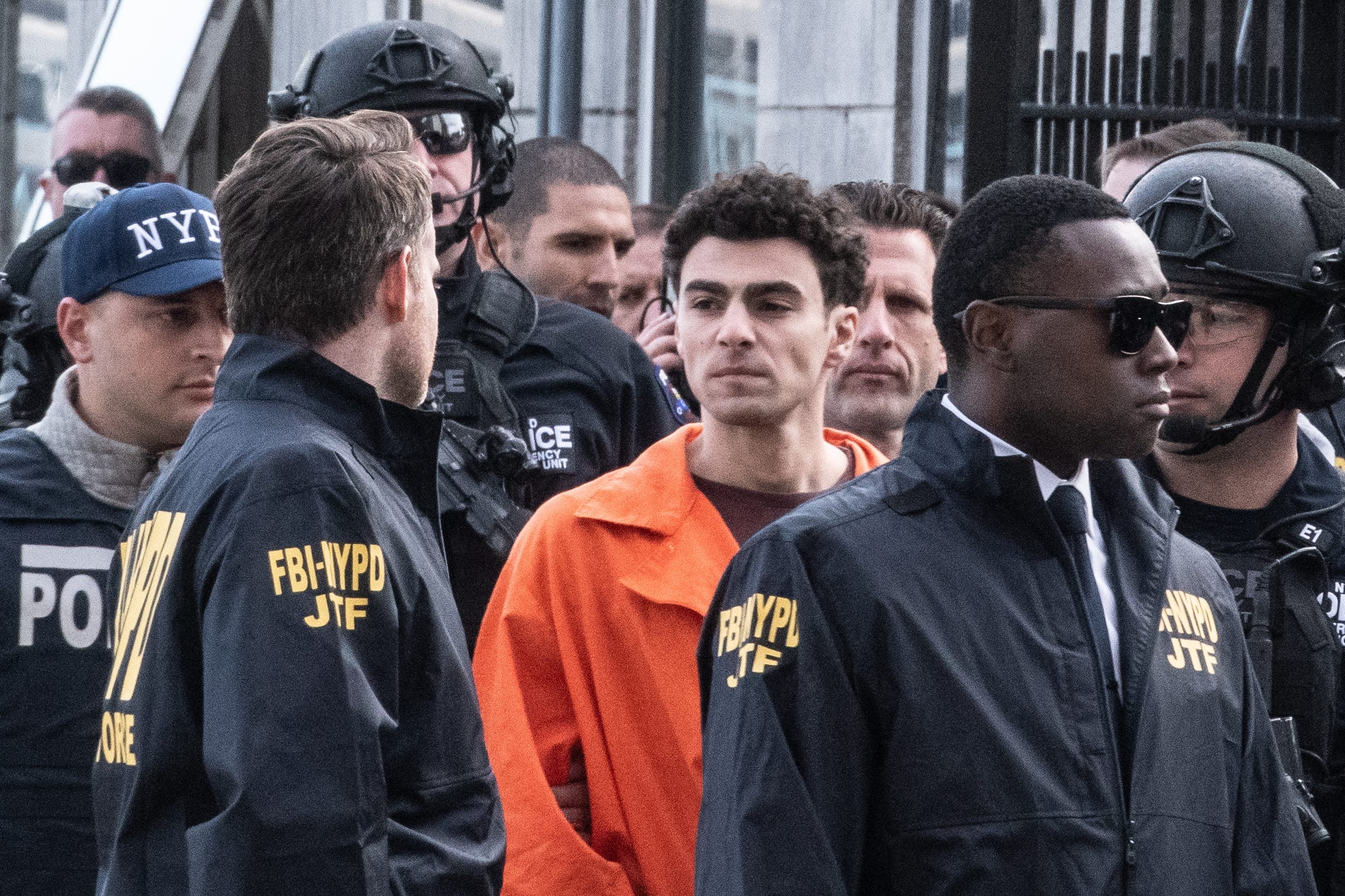 Luigi Mangione is shown being escorted by law enforcement after arriving in custody at a Manhattan heliport.