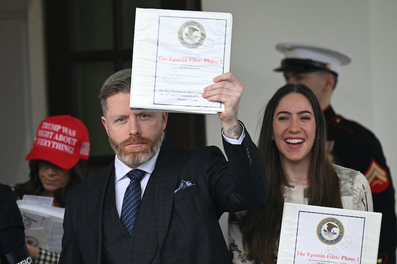 Political commentator Rogan O'Handley (C), aka DC Draino, US influencer Jessica Reed Kraus (L) and Chaya Raichik (R) carry binders bearing the seal of the US Justice Department reading