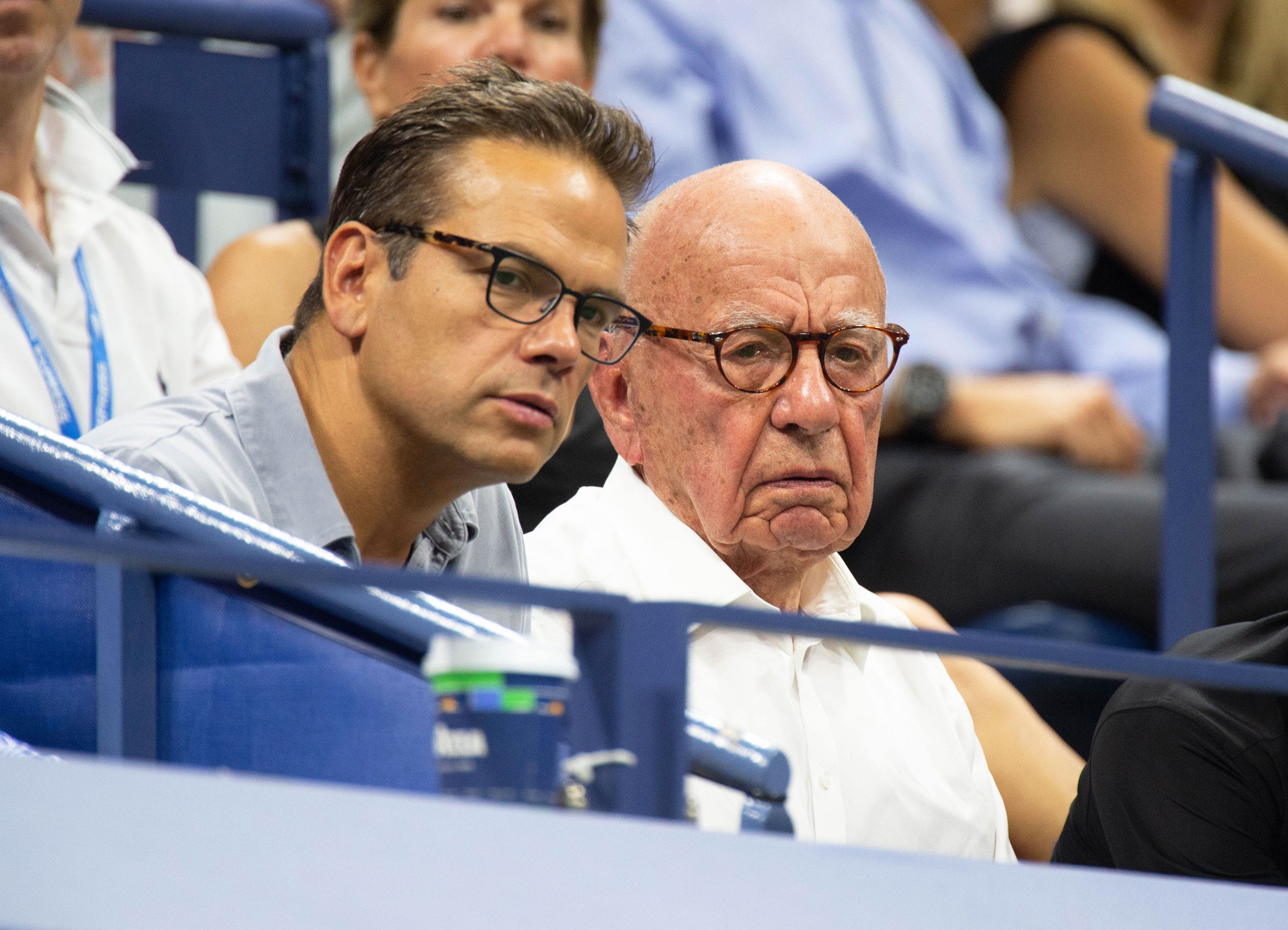 Lachlan Murdoch and Rupert Murdoch watching a tennis game.