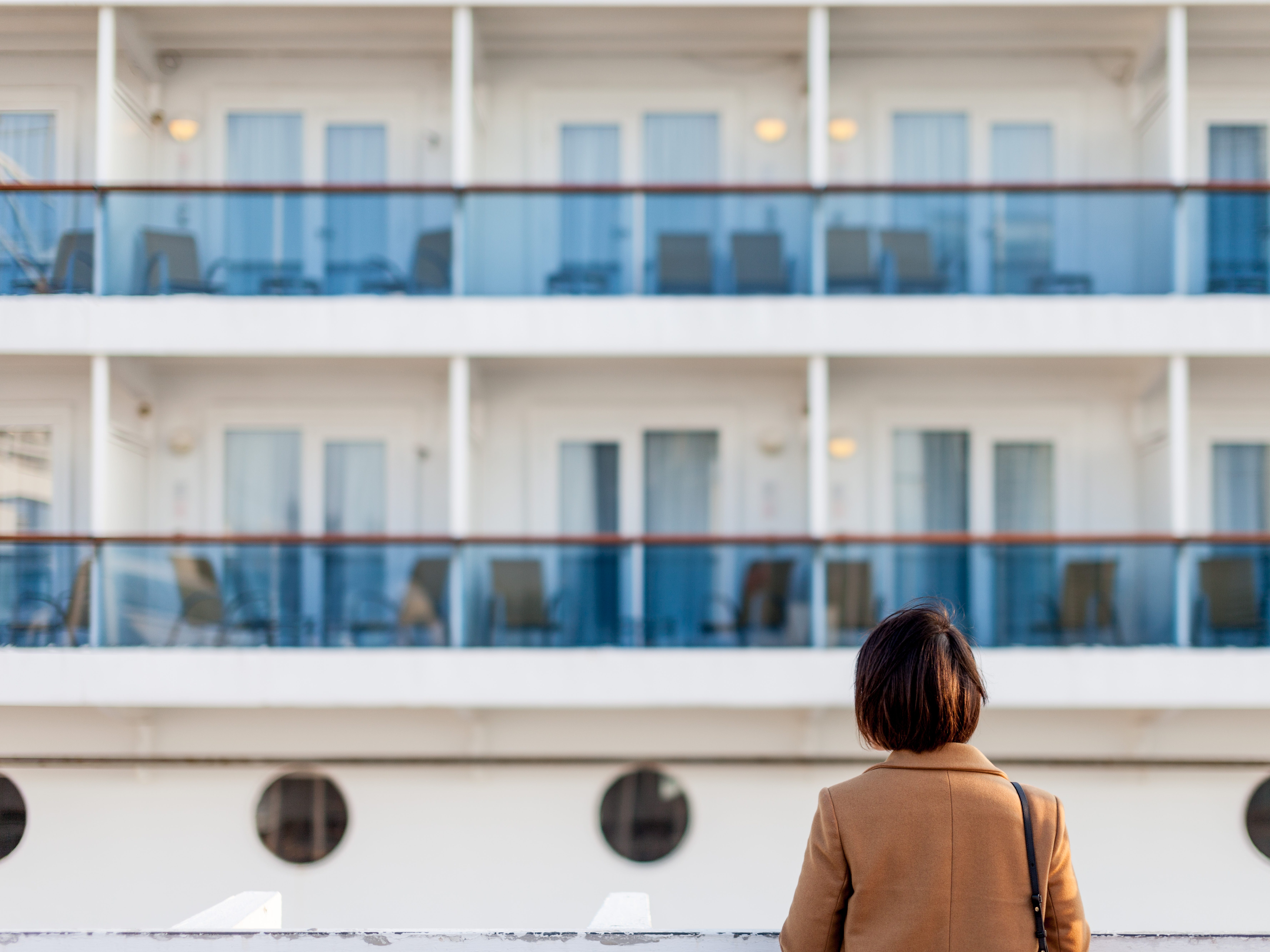 a woman facing a cruise ship