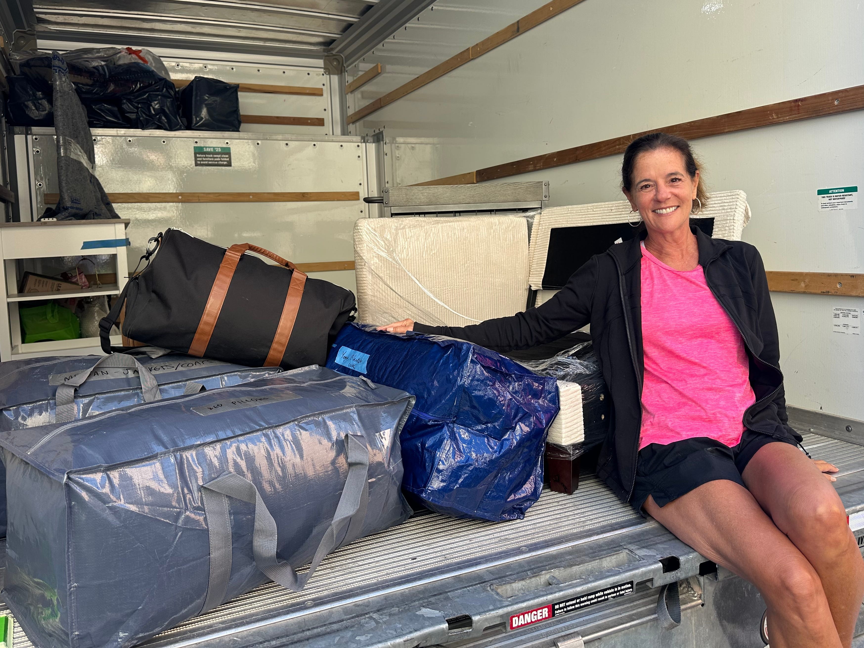 Christina Daves sitting in the back of a moving truck