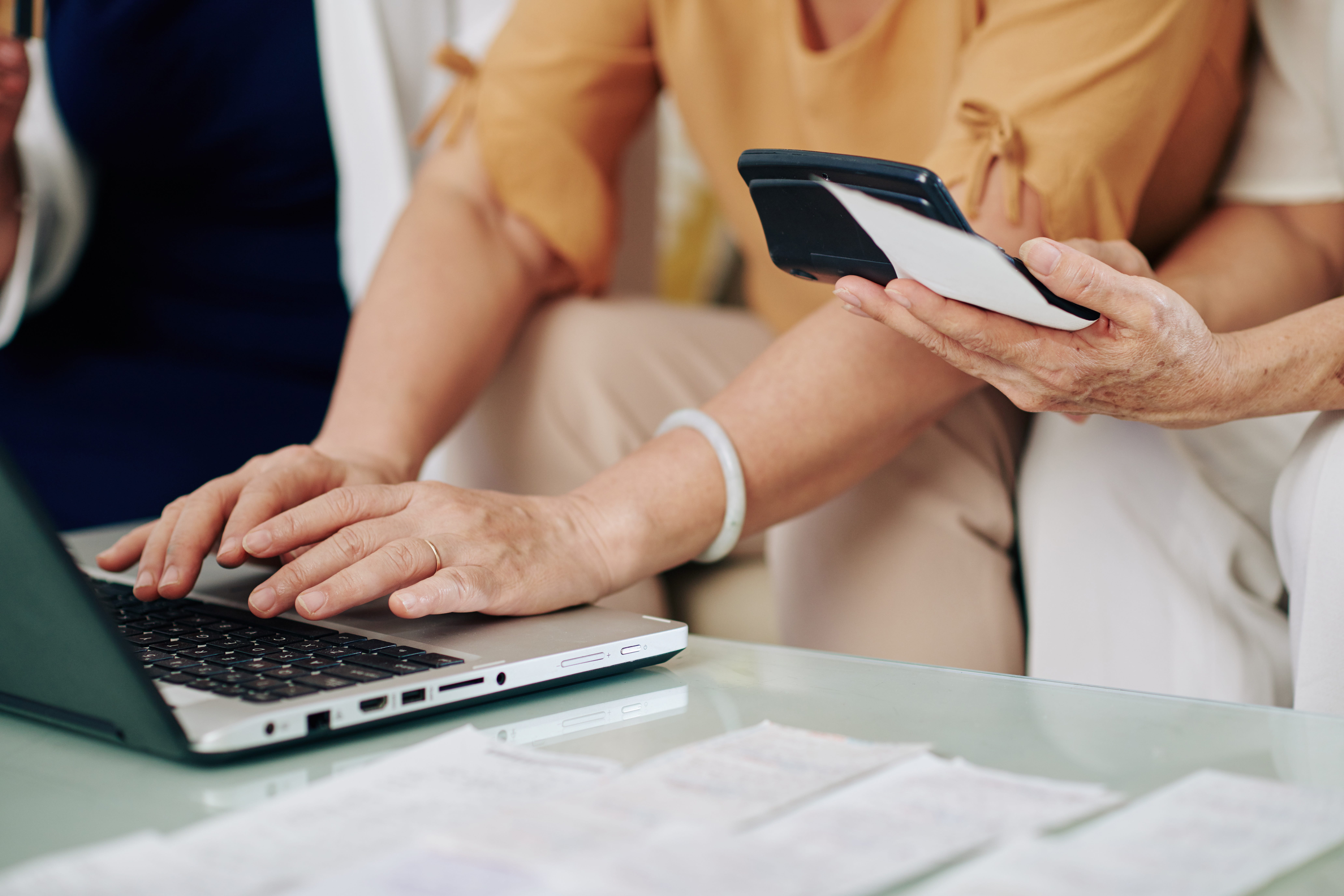 Close-up image of senior women counting expenses and paying bills online