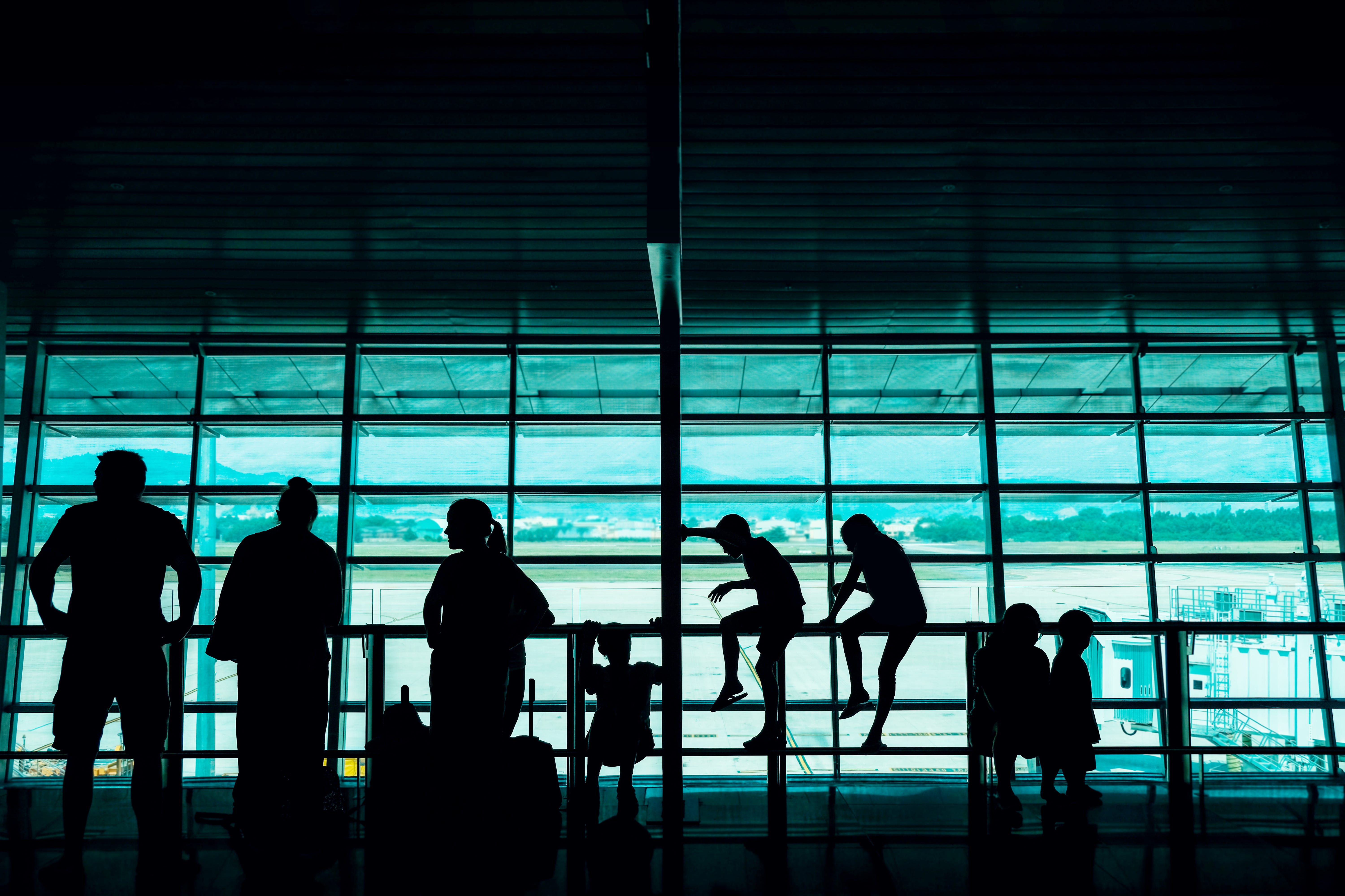 Silhouette of a Big Family Passengers Waiting for Boarding in the Departure Terminal at the Airport