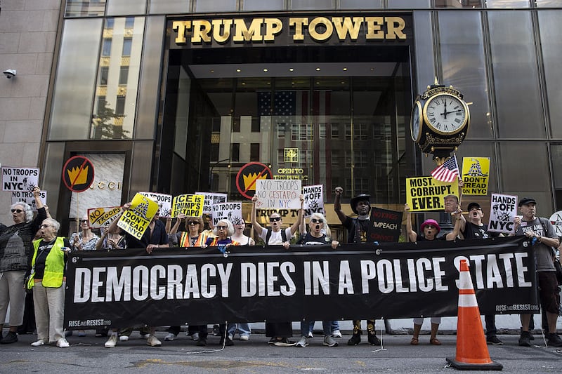 People, holding banners, gather outside Trump Tower to denounce U.S. President Donald Trump's threats to send military troops to New York City on September 13, 2025 in New York, United States. (Photo by Mostafa Bassim/Anadolu via Getty Images)