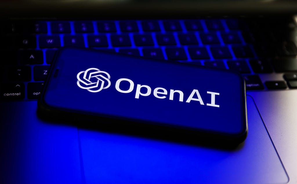 OpenAI logo displayed on a phone screen and a laptop keyboard are seen in this illustration photo taken in Poland on April 24, 2022.