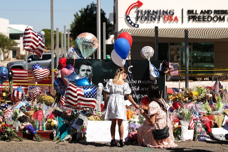People gather at a makeshift memorial for political activist and Turning Point USA Founder Charlie Kirk outside of the Turning Point USA headquarters in Phoenix, Arizona, on September 14, 2025. The widow of prominent right-wing activist Charlie Kirk pledged on September 12 to carry on her husband's work, after US authorities announced his alleged assassin had finally been captured. The 31-year-old Kirk was hit by a single bullet while addressing a large crowd at Utah Valley University in the town of Orem on September 10. (Photo by CHARLY TRIBALLEAU / AFP) (Photo by CHARLY TRIBALLEAU/AFP via Getty Images)
