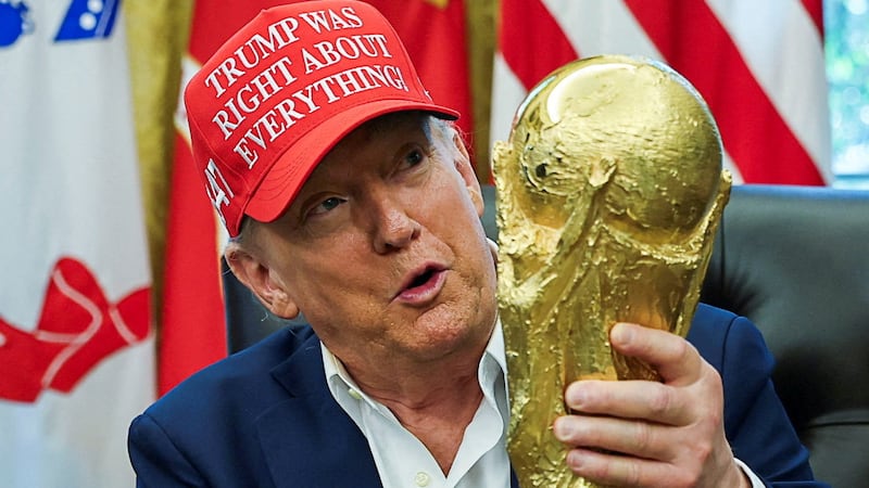 U.S. President Donald Trump wears a 'Trump Was Right About Everything!' hat while holding the FIFA World Cup Trophy, as he makes an announcement on the 2026 FIFA World Cup, in the Oval Office at the White House in Washington, D.C., U.S., August 22, 2025. REUTERS/Jonathan Ernst/File Photo