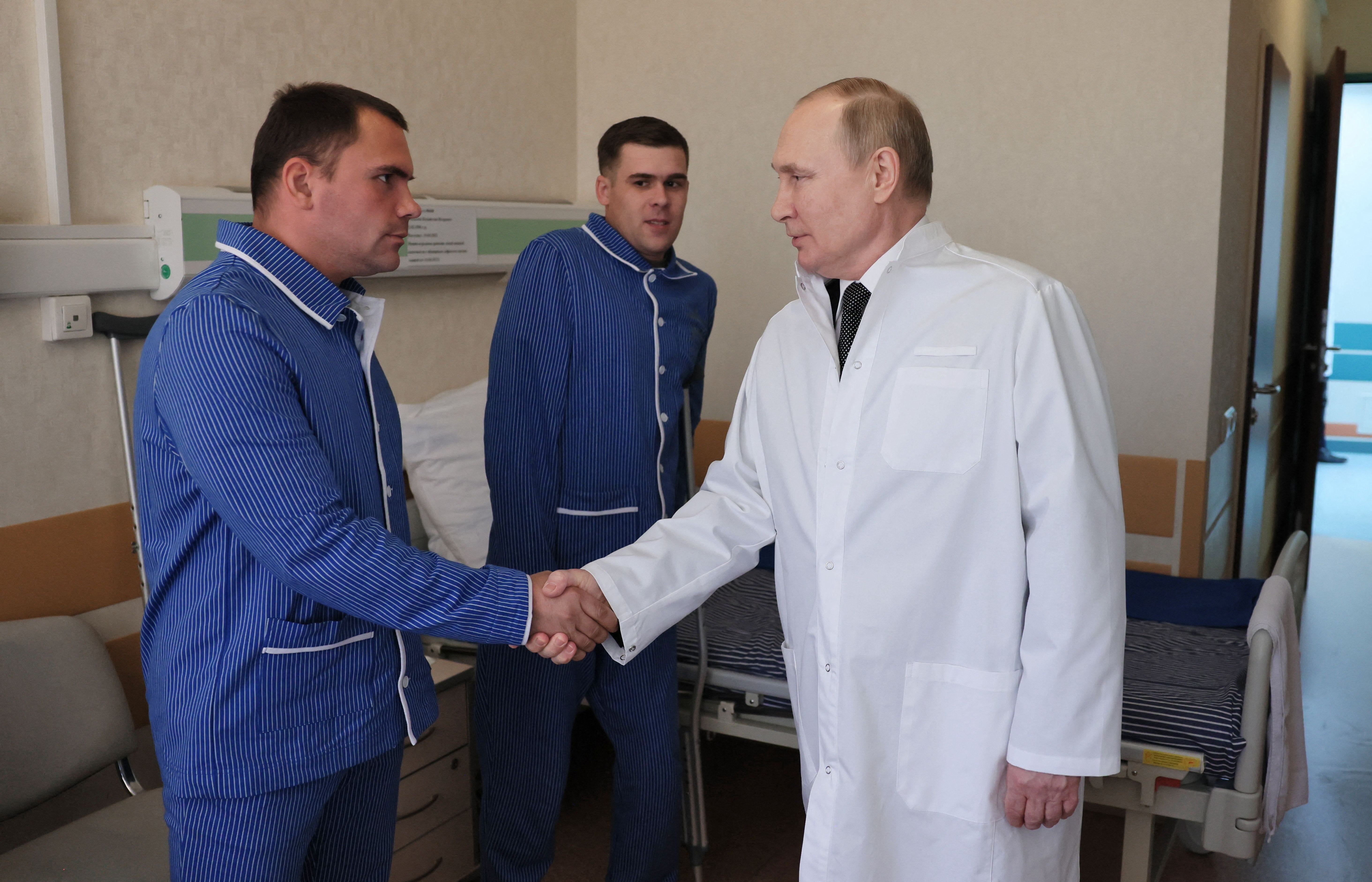 Russian President Vladimir Putin visits servicemen who were wounded during the Russian war in Ukraine, at a military hospital in Moscow on May 25, 2022.