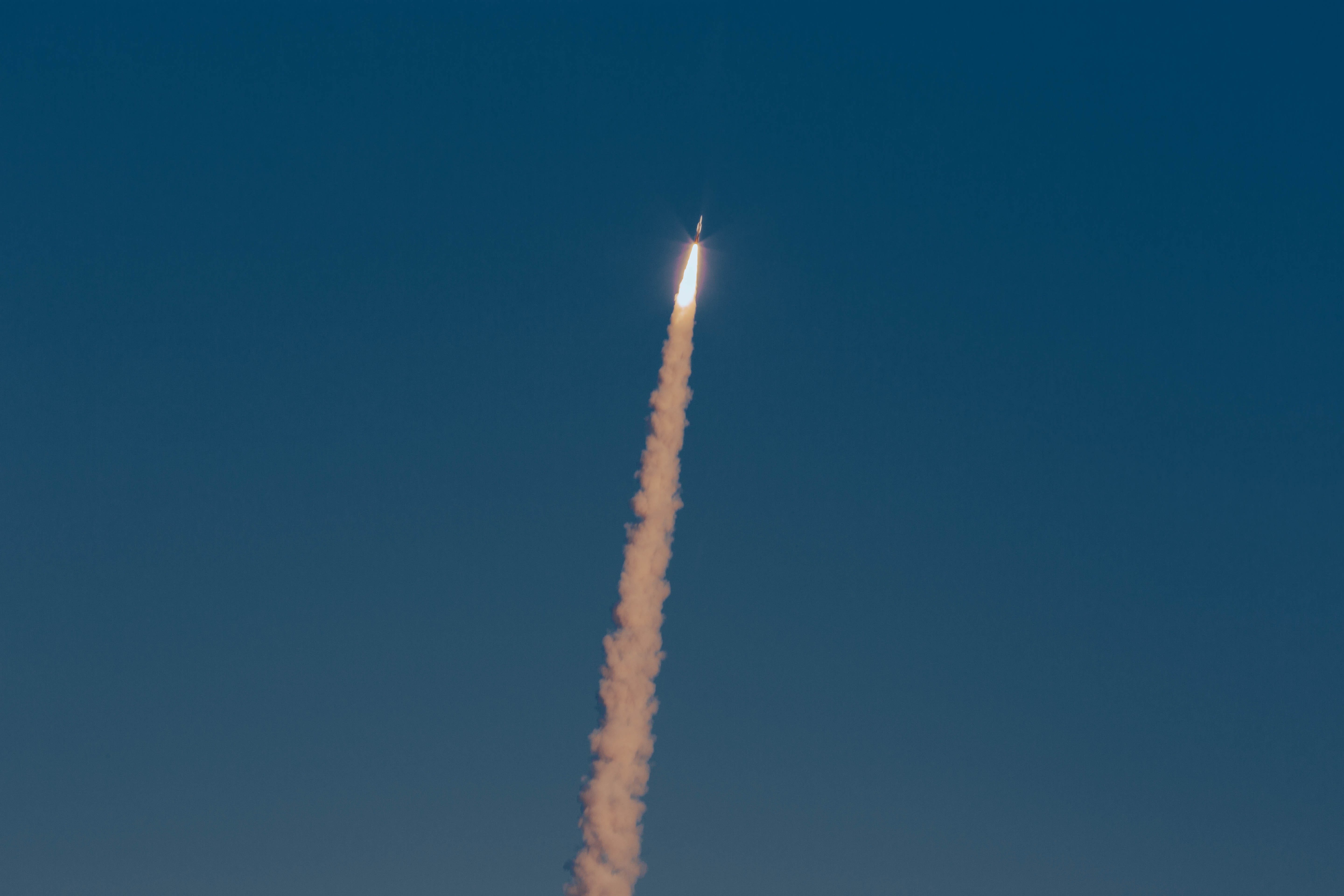 A Standard Missile-6 is fired into the air from the Mid-Range Capability missile launcher. The sky is clear blue in the background.