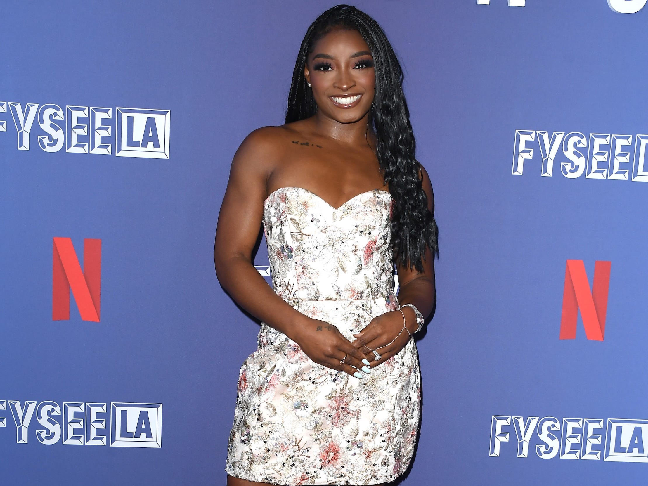 Simone Biles poses on a purple carpet at a Netflix event in Hollywood, hosted to promote the 