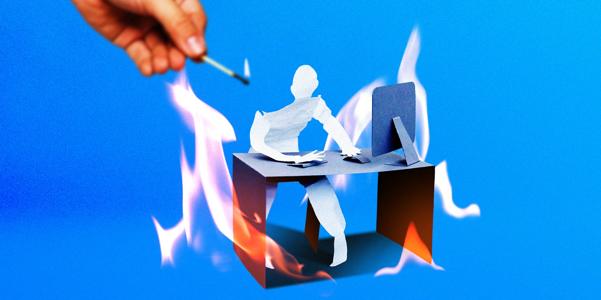 A paper figure and desk being lit on fire
