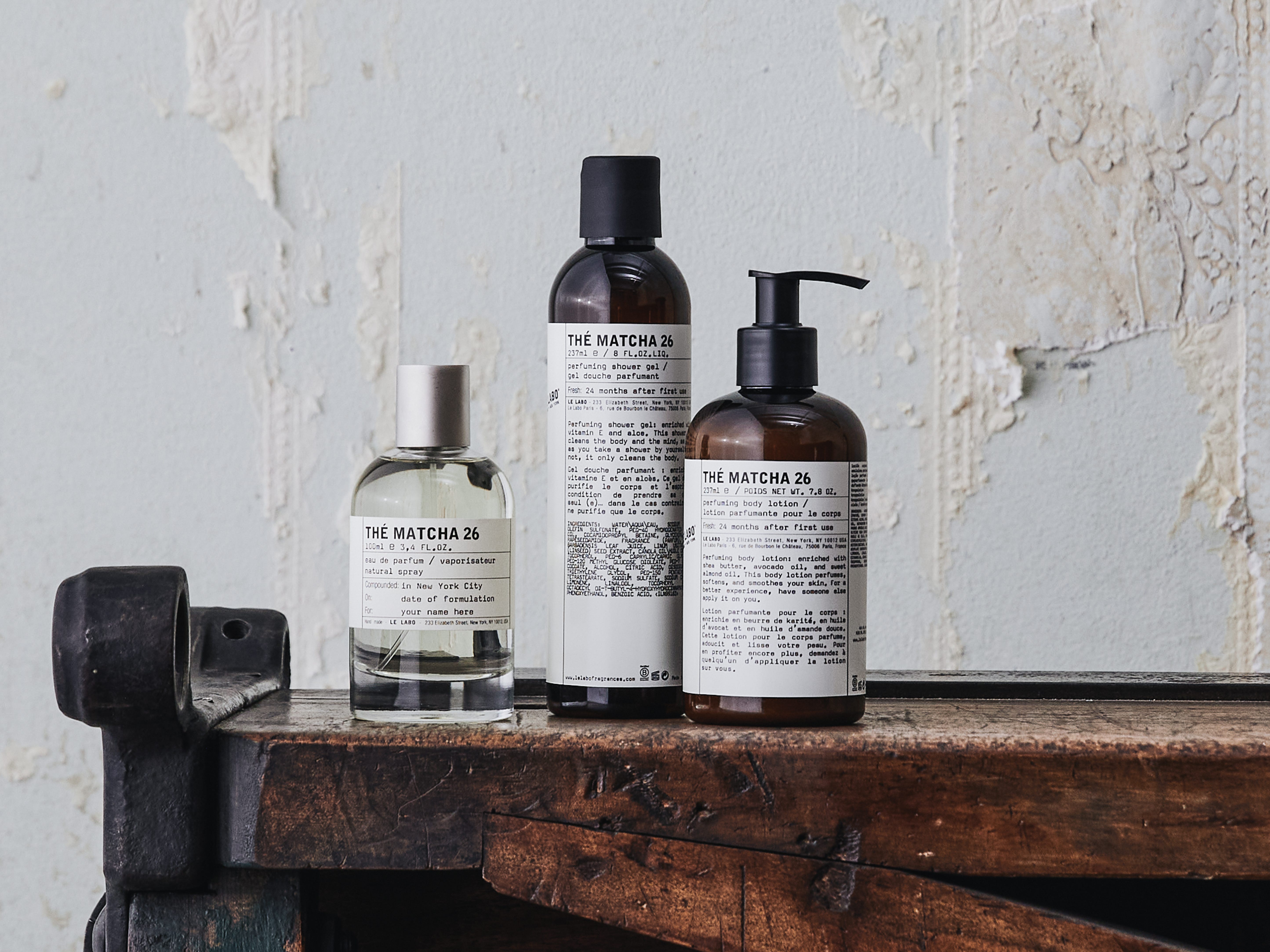 Three Le Labo products in Thé Matcha 26 scent displayed on a wooden table.