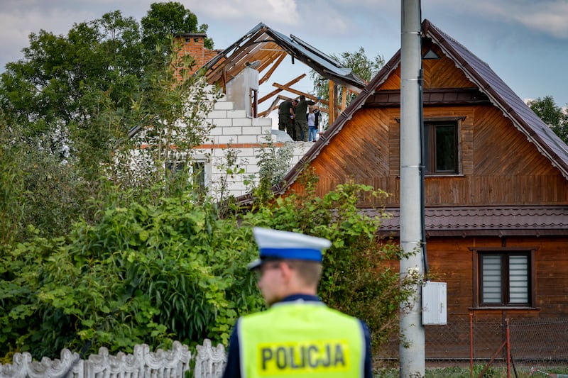 Police and army inspect damage to a house destroyed by debris from a shot down Russian drone in the village of Wyryki-Wola, eastern Poland.