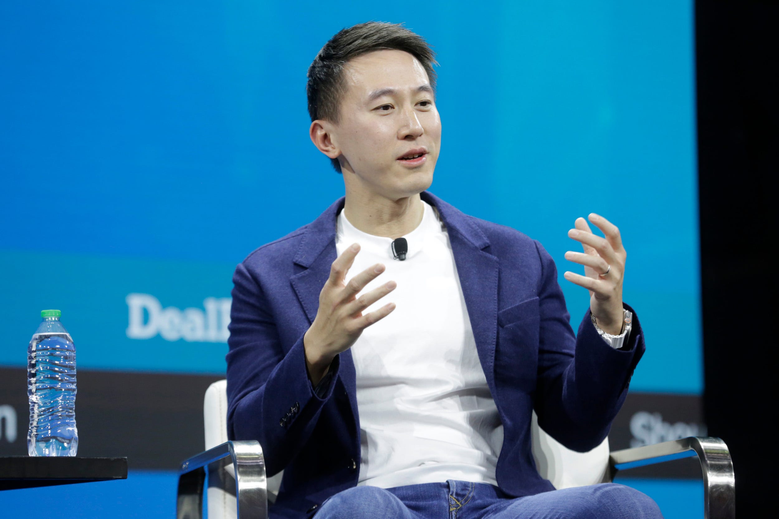 TikTok CEO Shou Chew speaks at the New York Times DealBook conference wearing a blue blazer and sitting in front of a blue background.