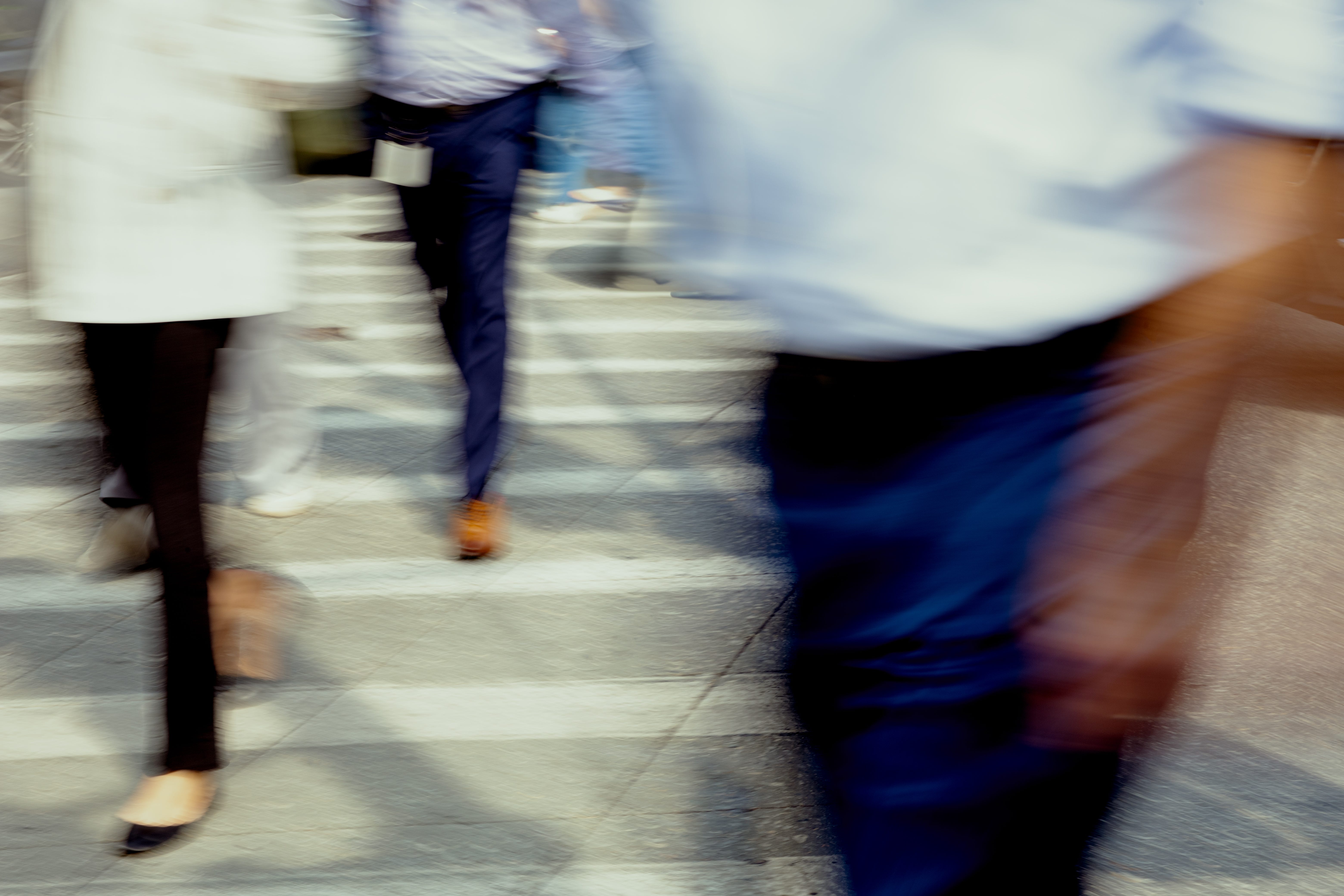 People in suits cross the street