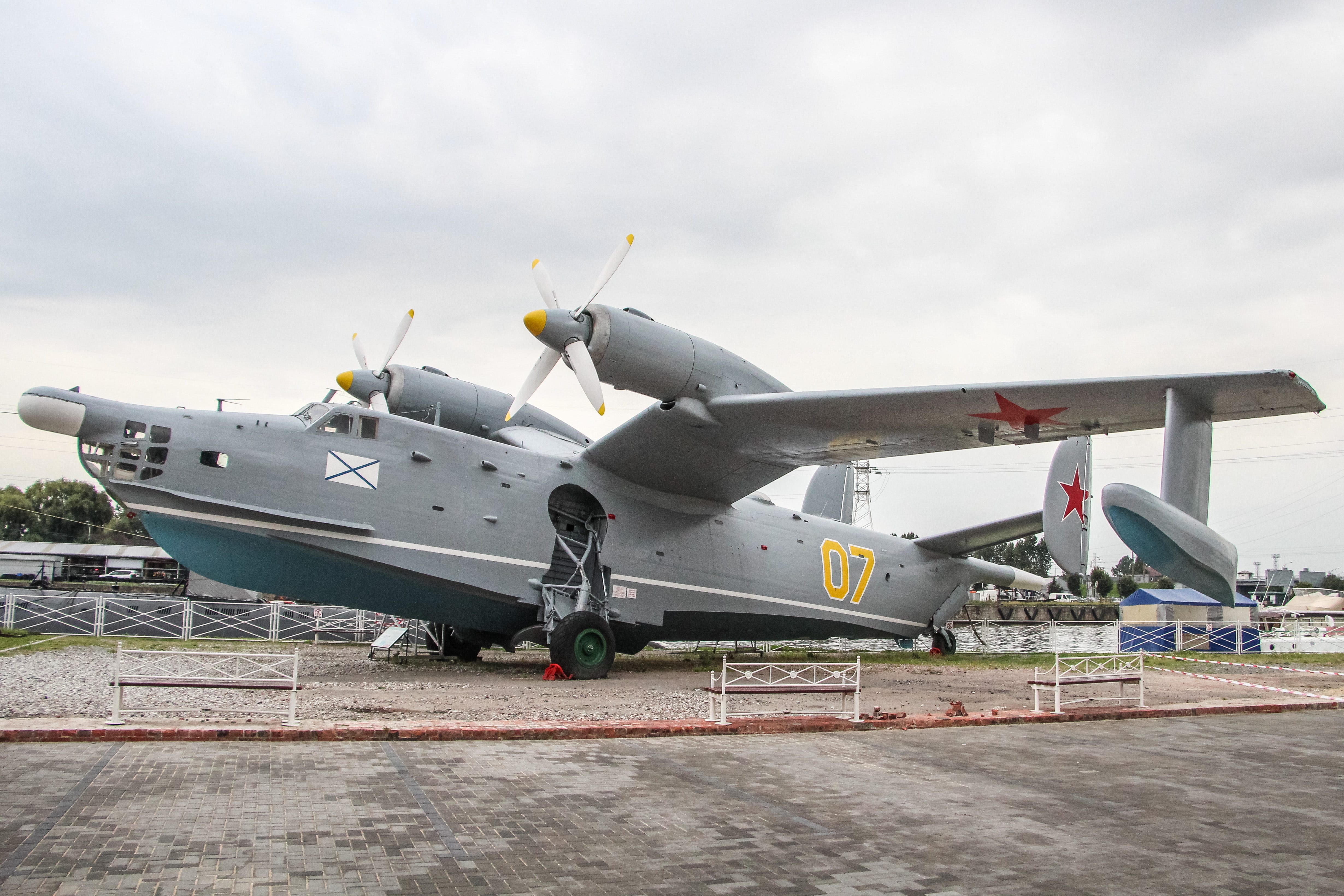 A grey aircraft on top of grey concrete under a grey sky