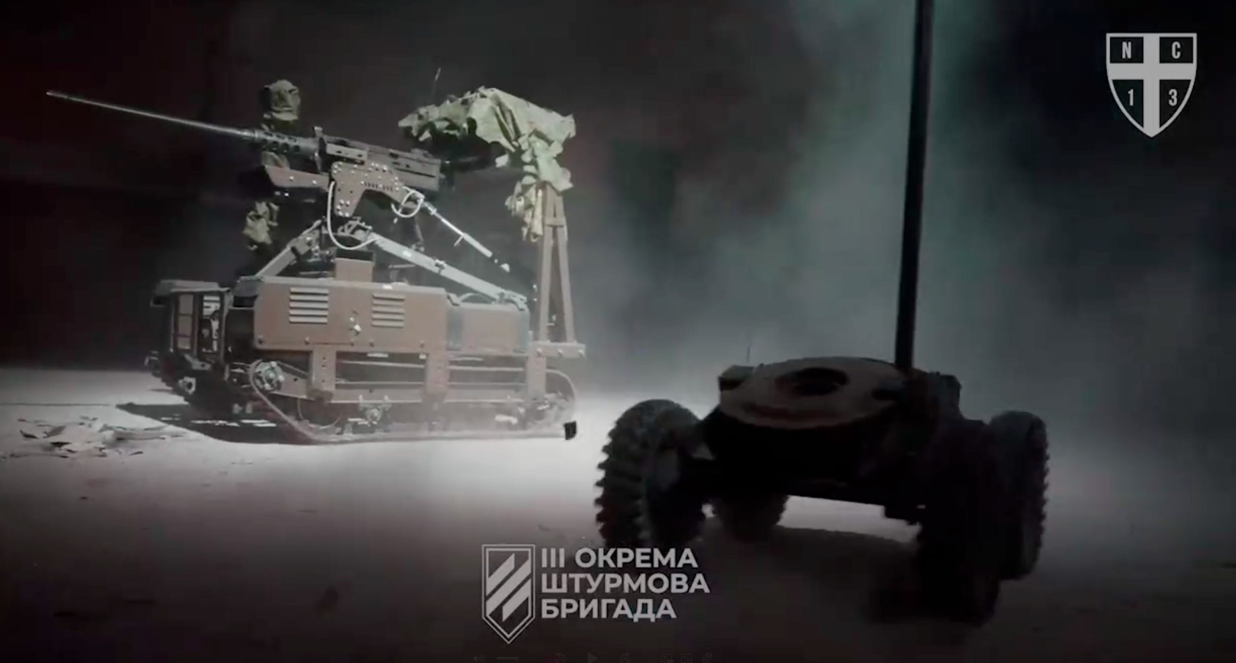 Two UGVs designed for combat perform maneuvers in a warehouse.