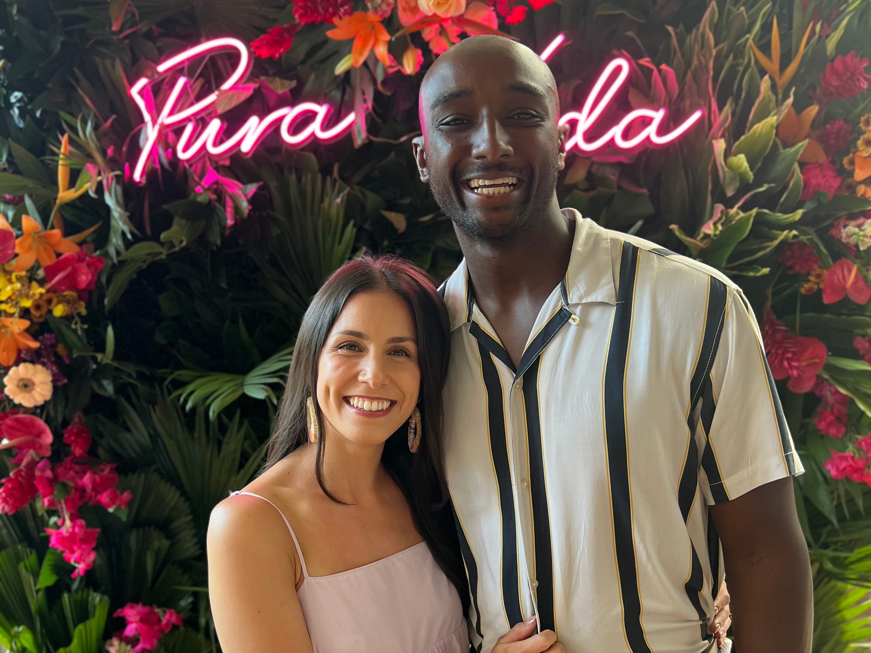 Man and woman pose in front of flowers