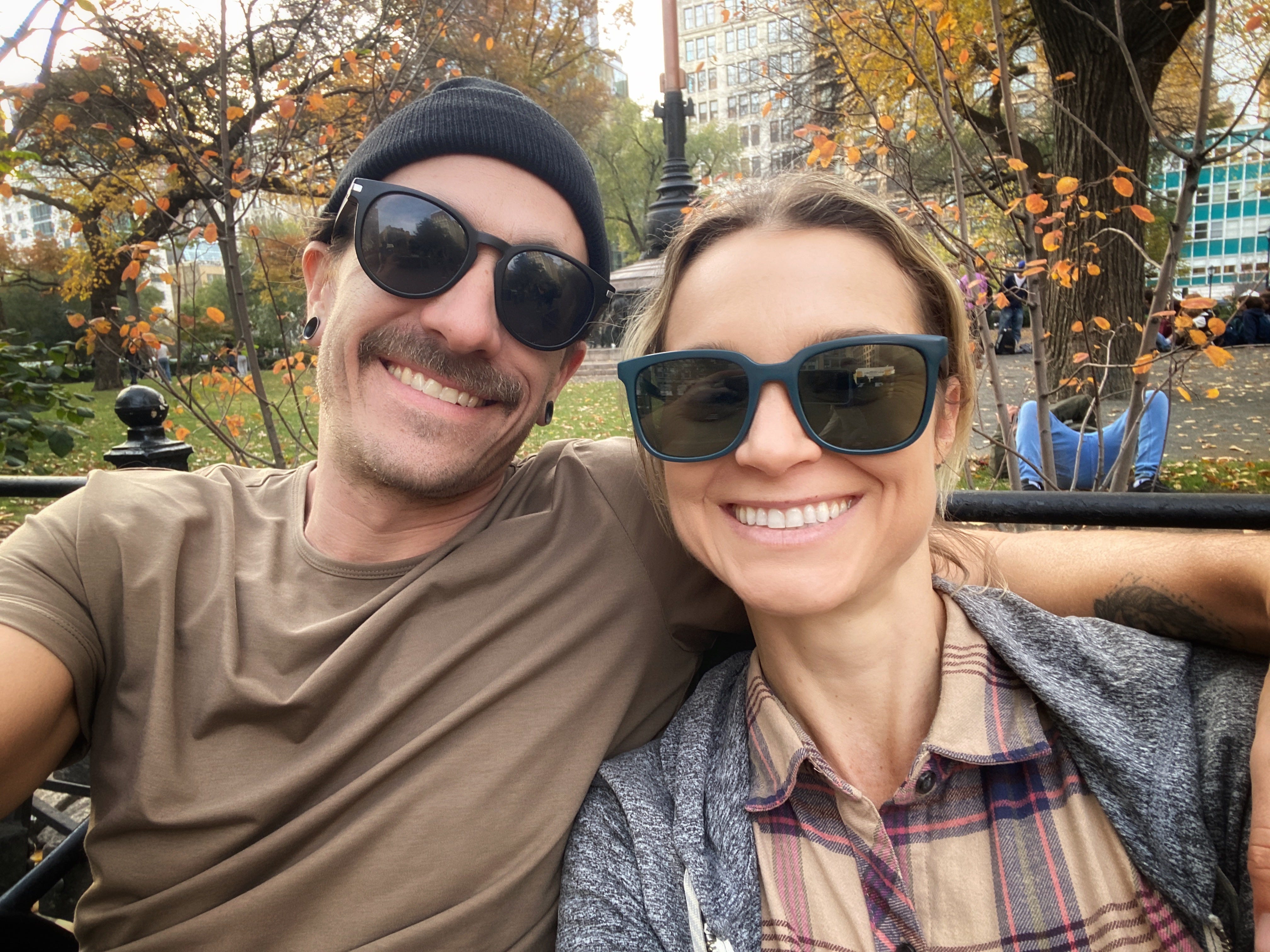 Woman and man wearing sunglasses on bench in park